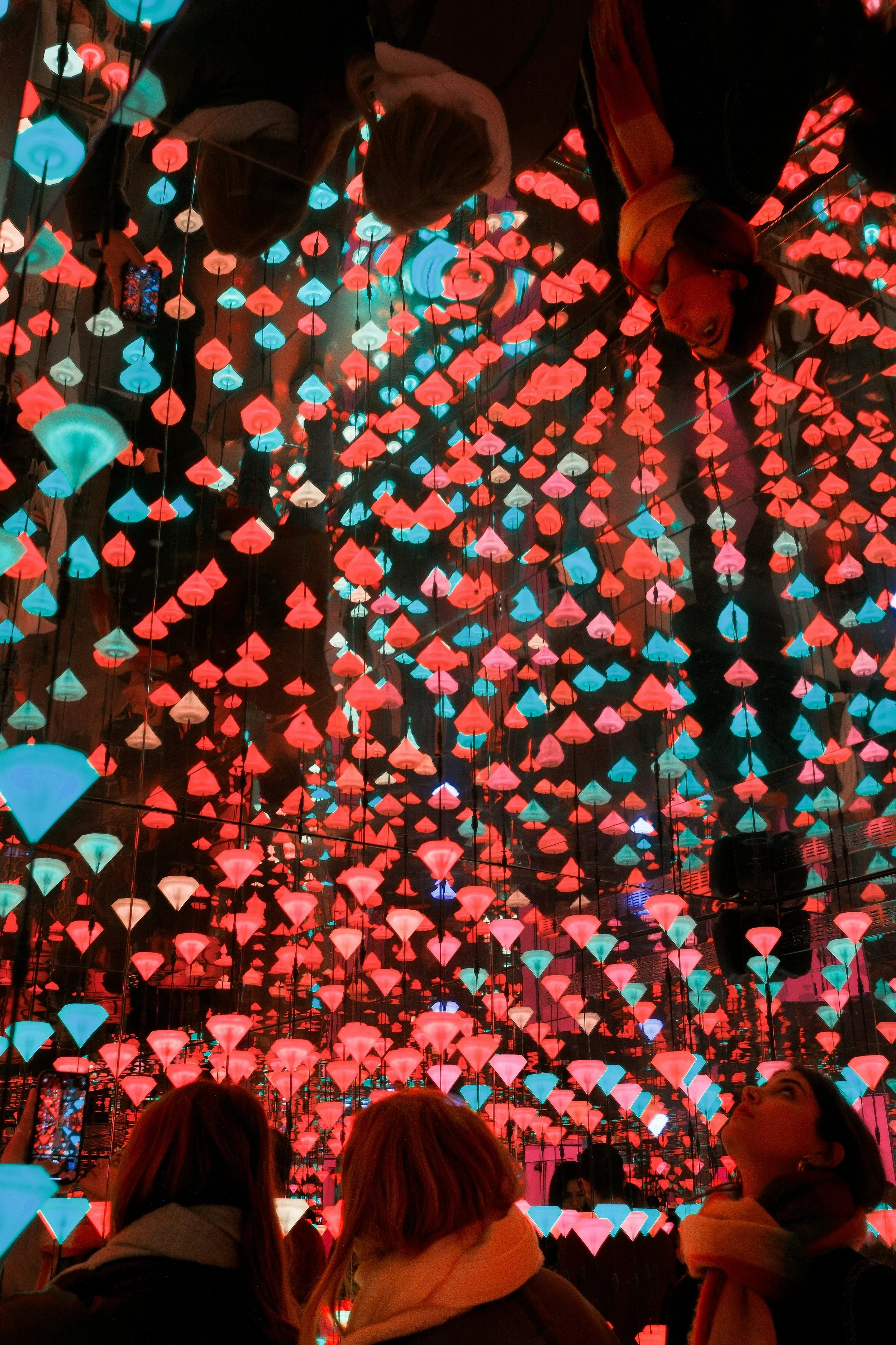Visitors inside a mirrored light installation
