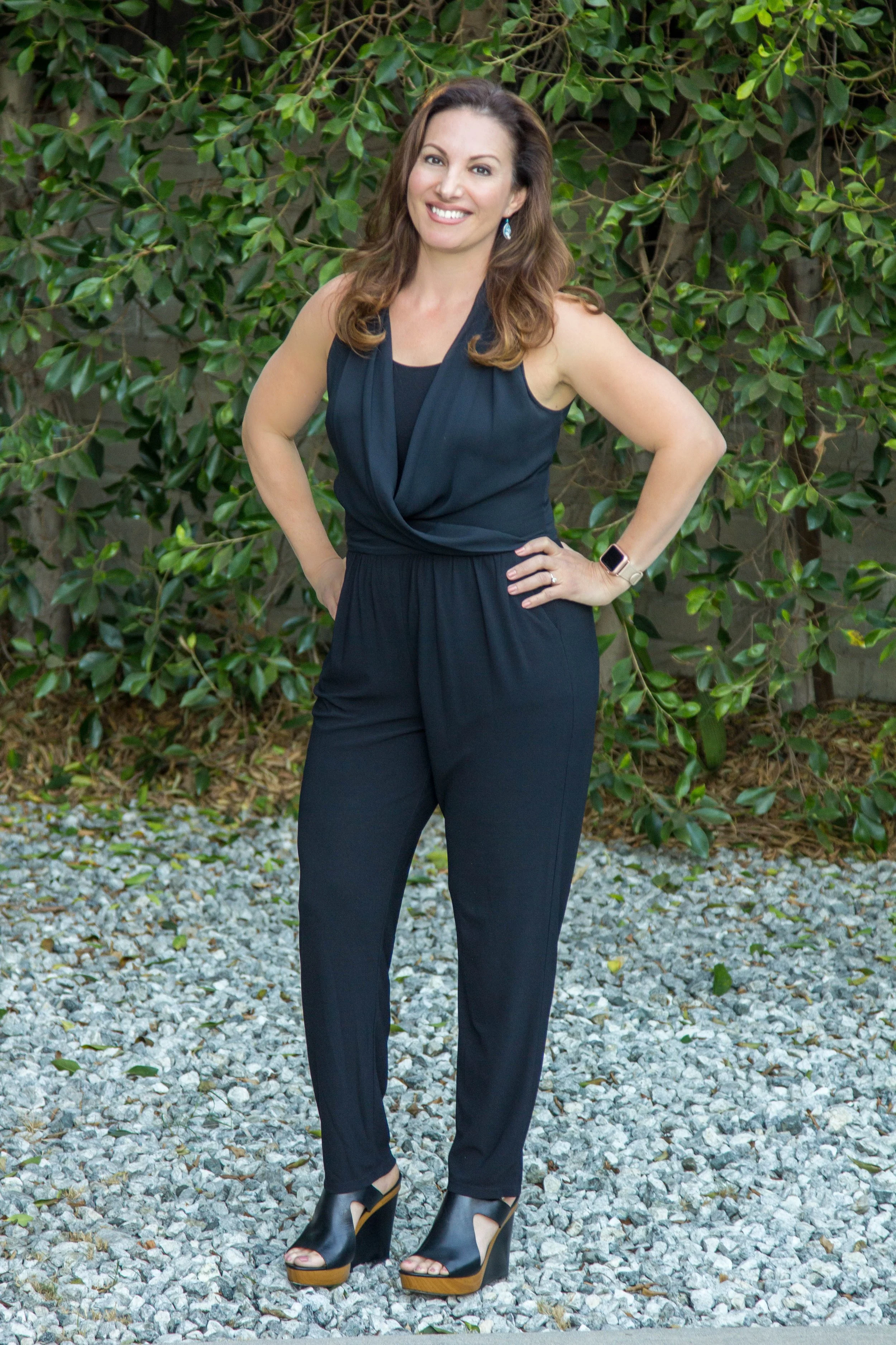 Maribel Dugas, LCSW, Zen & Health, Maribel con vestido negro, sonriendo, fondo naturaleza