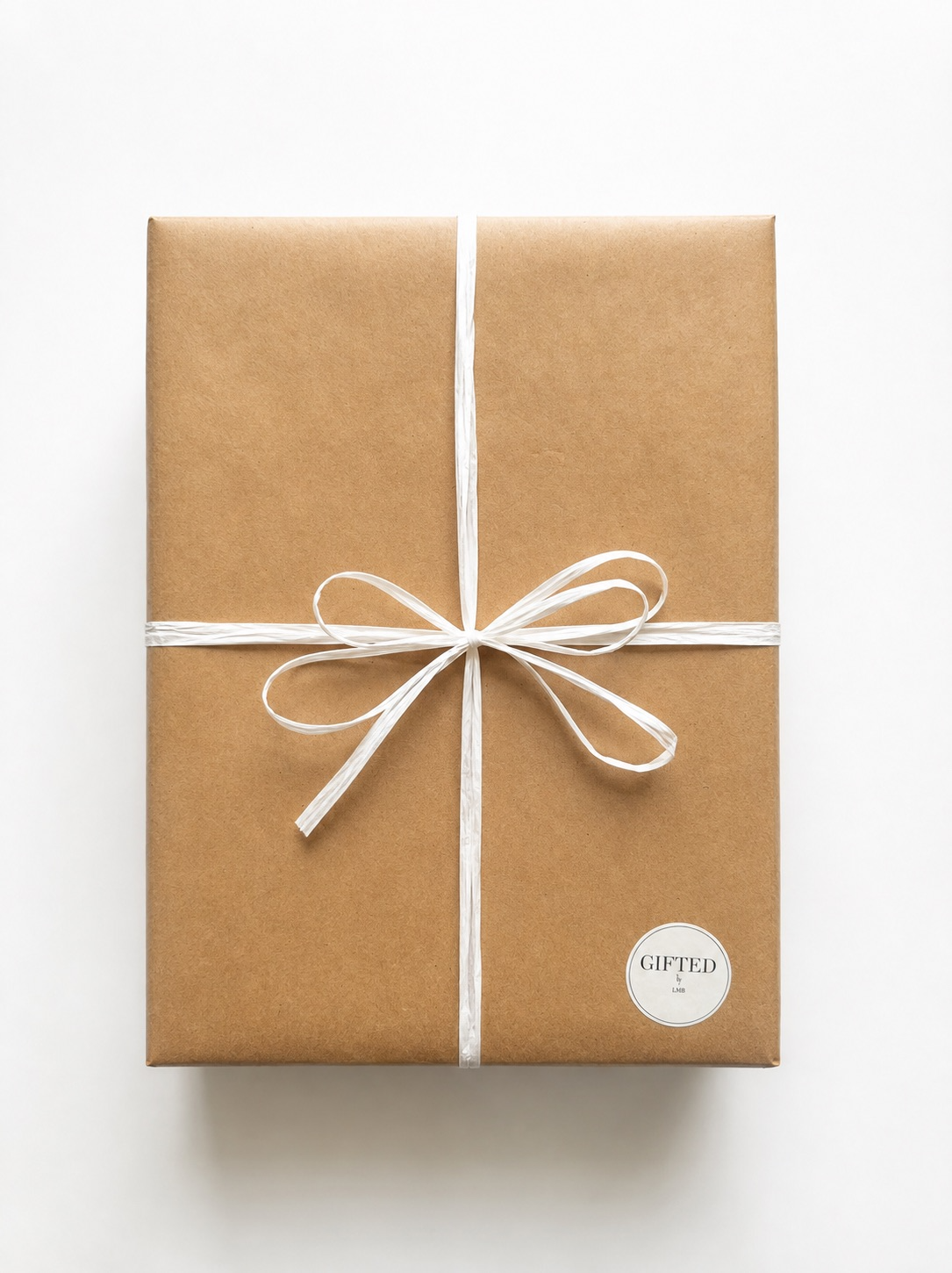 Wrapped gift box in brown paper with white ribbon and bow, label reads "GIFTED".