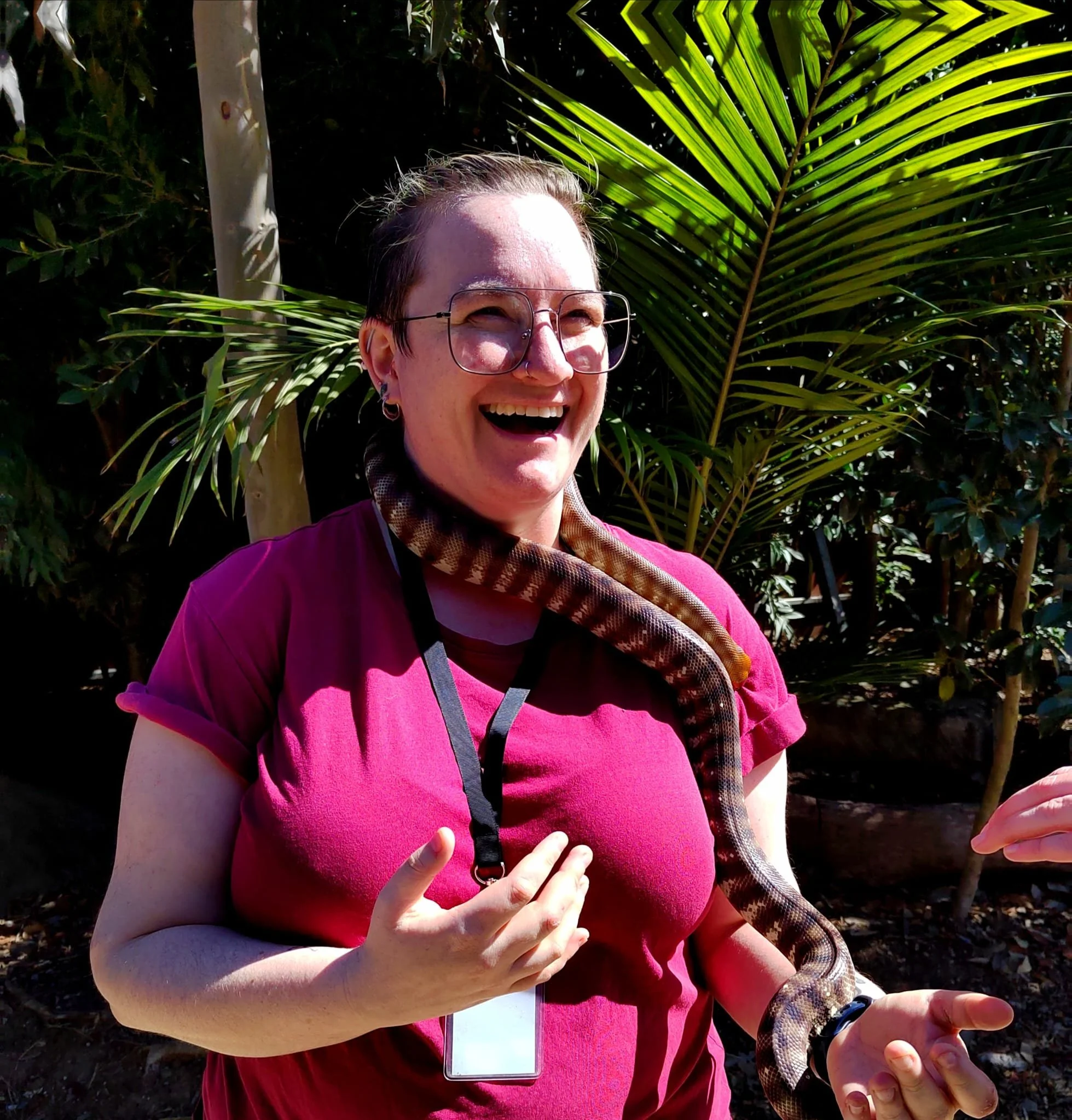 Eleanor Coates, Production Manager and Line Producer, holding a snake outdoors.