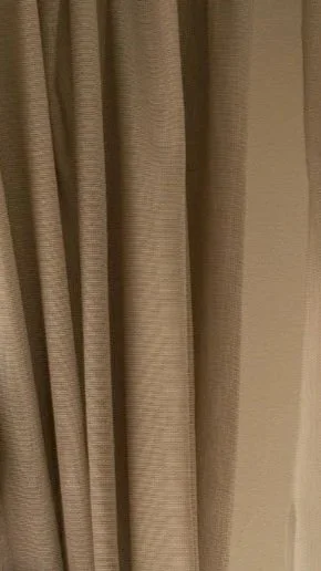 Close-up of beige curtains hanging vertically.