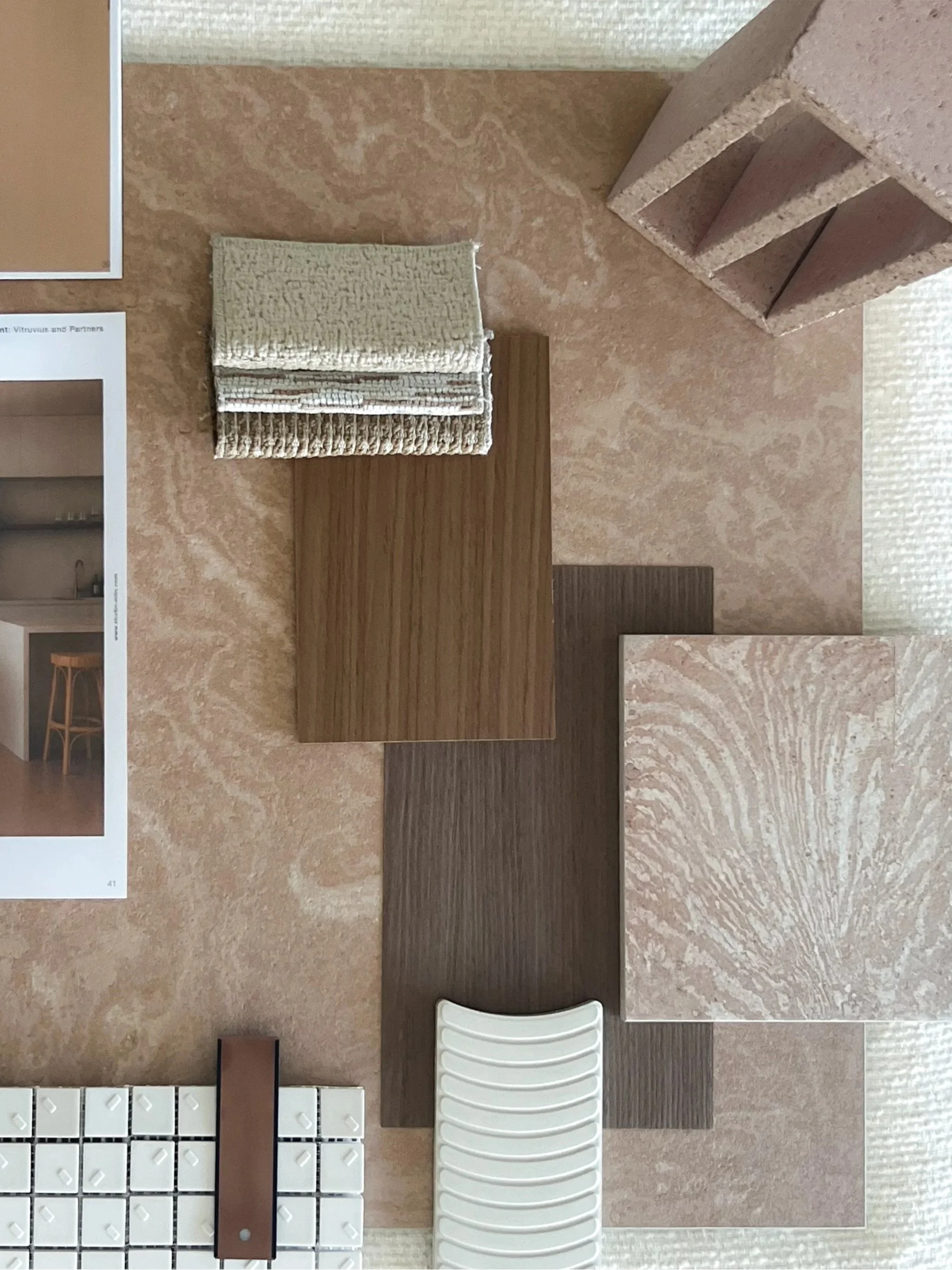 Various sample materials such as fabric swatches, wood, marble, and tiles displayed on a table or surface.