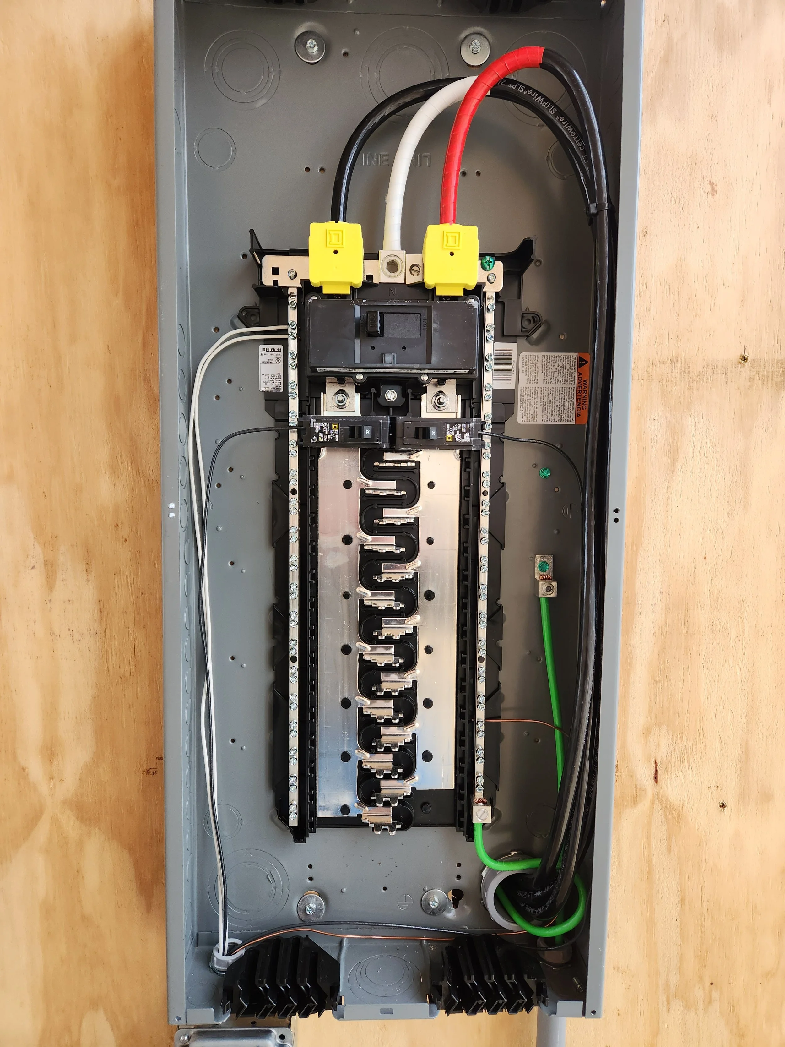 Inside an empty electrical breaker box with wires and circuit breakers.