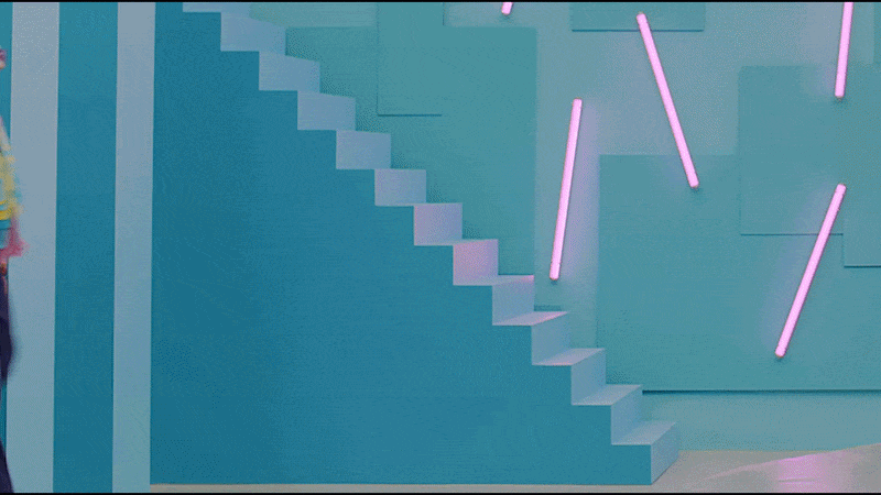 Blue staircase with neon pink lights on a teal wall.