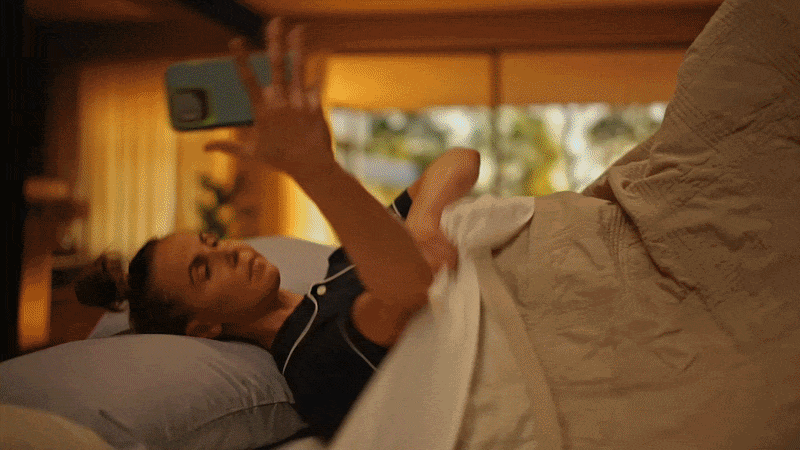 Woman lying in bed and taking a selfie with her phone