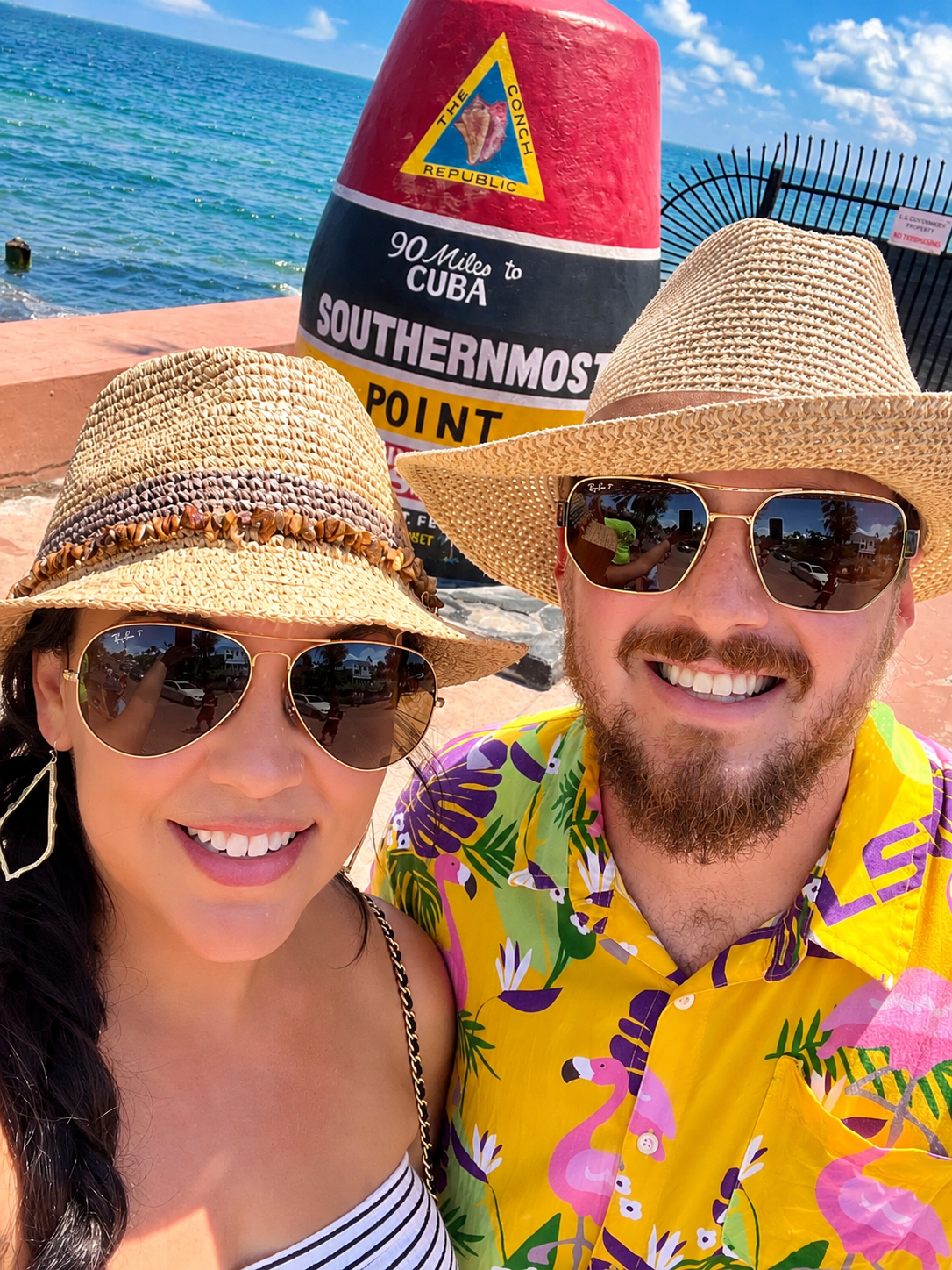 Stephanie and her husband taking a selfie at the Southernmost Point buoy in Key West