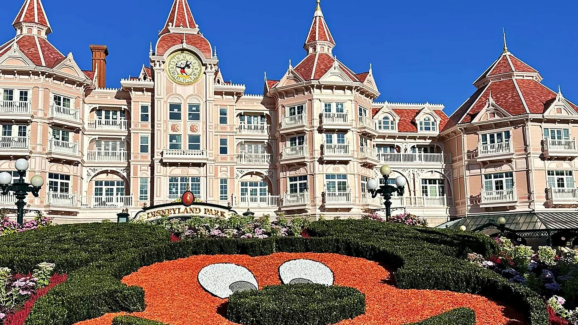 Disneyland Hotel above the Mickey Mouse floral display at the entrance to Disneyland Park