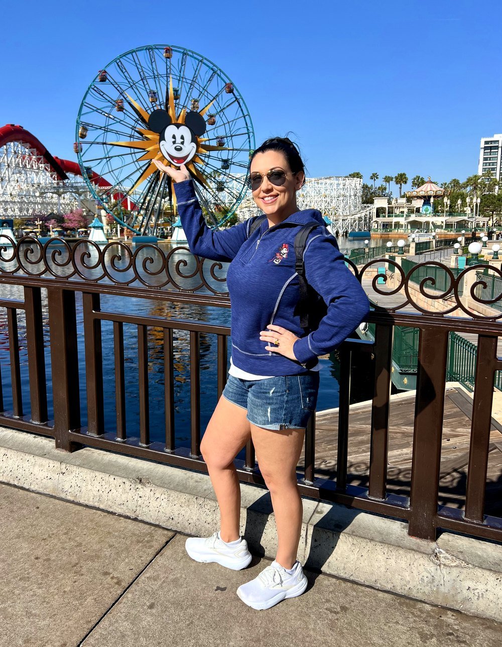 Stephanie posing with the Mickey ferris wheel at Pixar Pier