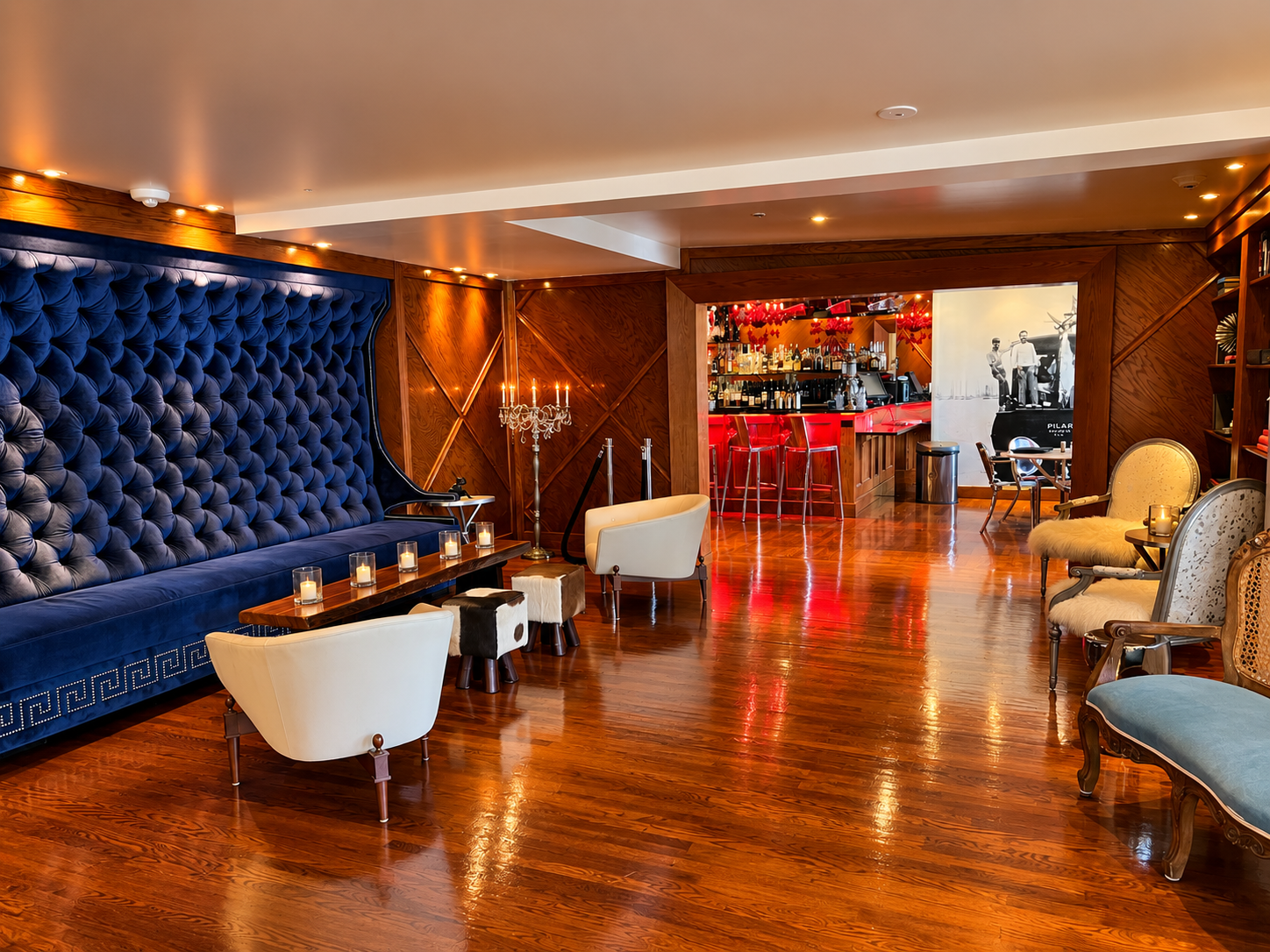 Blue velvet lounge with a jewel-toned bar at The Saint Hotel in Key West