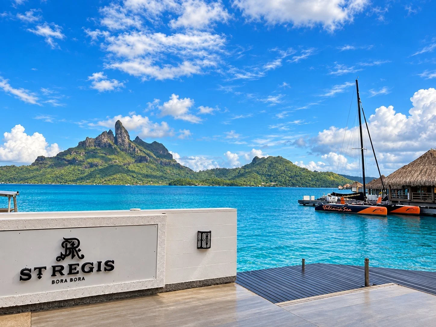 St. Regis Bora Bora entrance sign with Mount Otemanu across the lagoon.