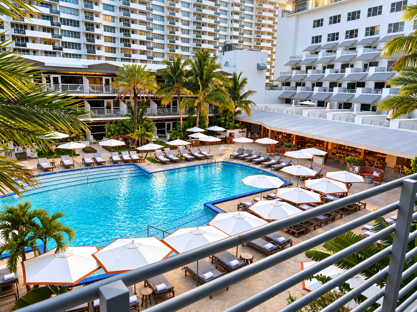 Pool deck with palm trees and white umbrellas at The Ritz-Carlton, South Beach in Miami Beach