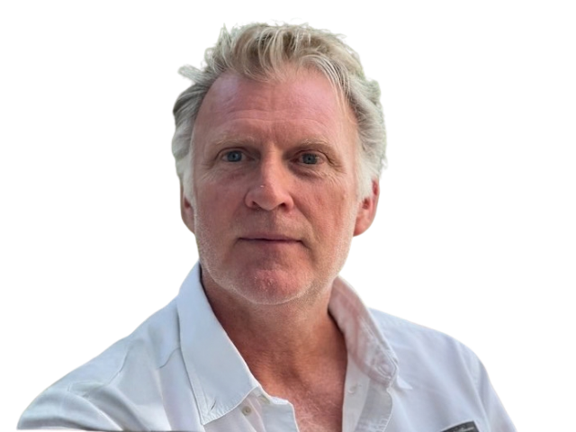 A middle-aged Caucasian man with gray hair and a serious expression, wearing a white collared shirt, against a black background.