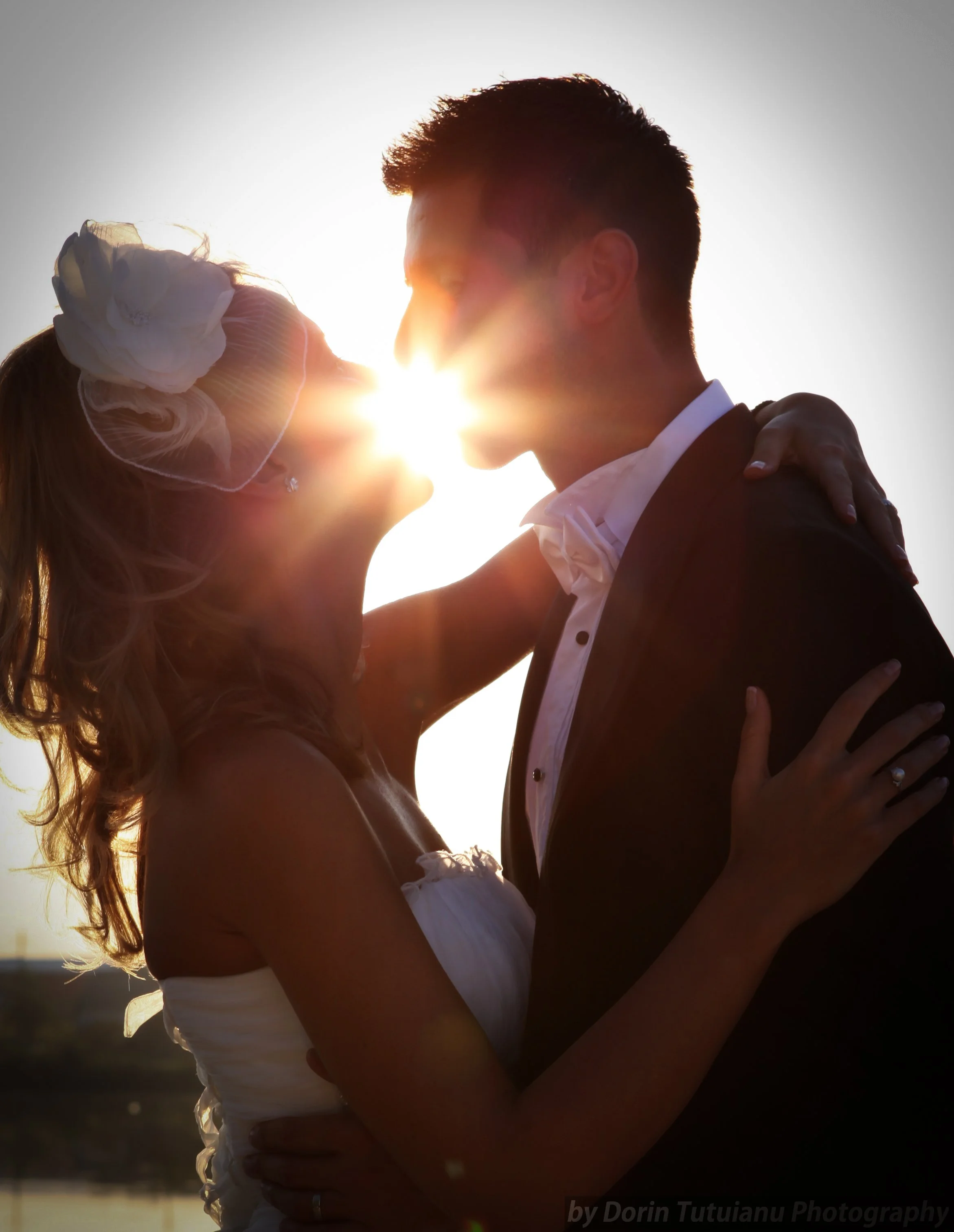 A couple with their foreheads touching, embracing at sunset, creating a romantic silhouette shot.
