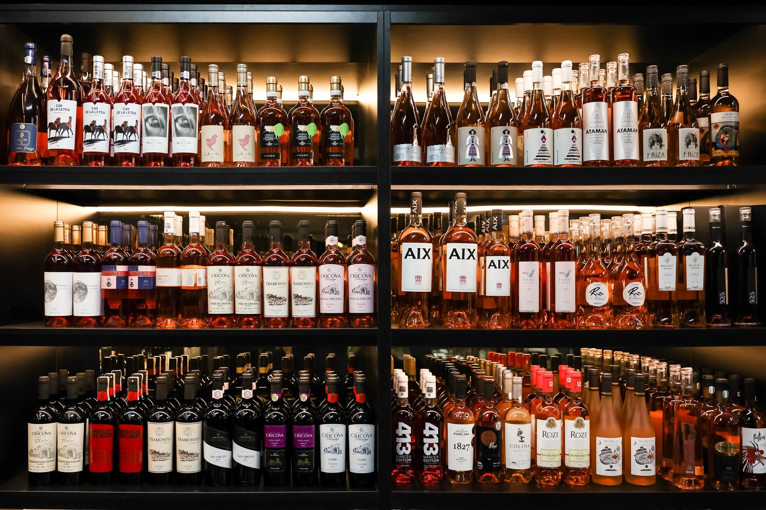 Shelf of various bottles of rosé wine in a store or wine shop.