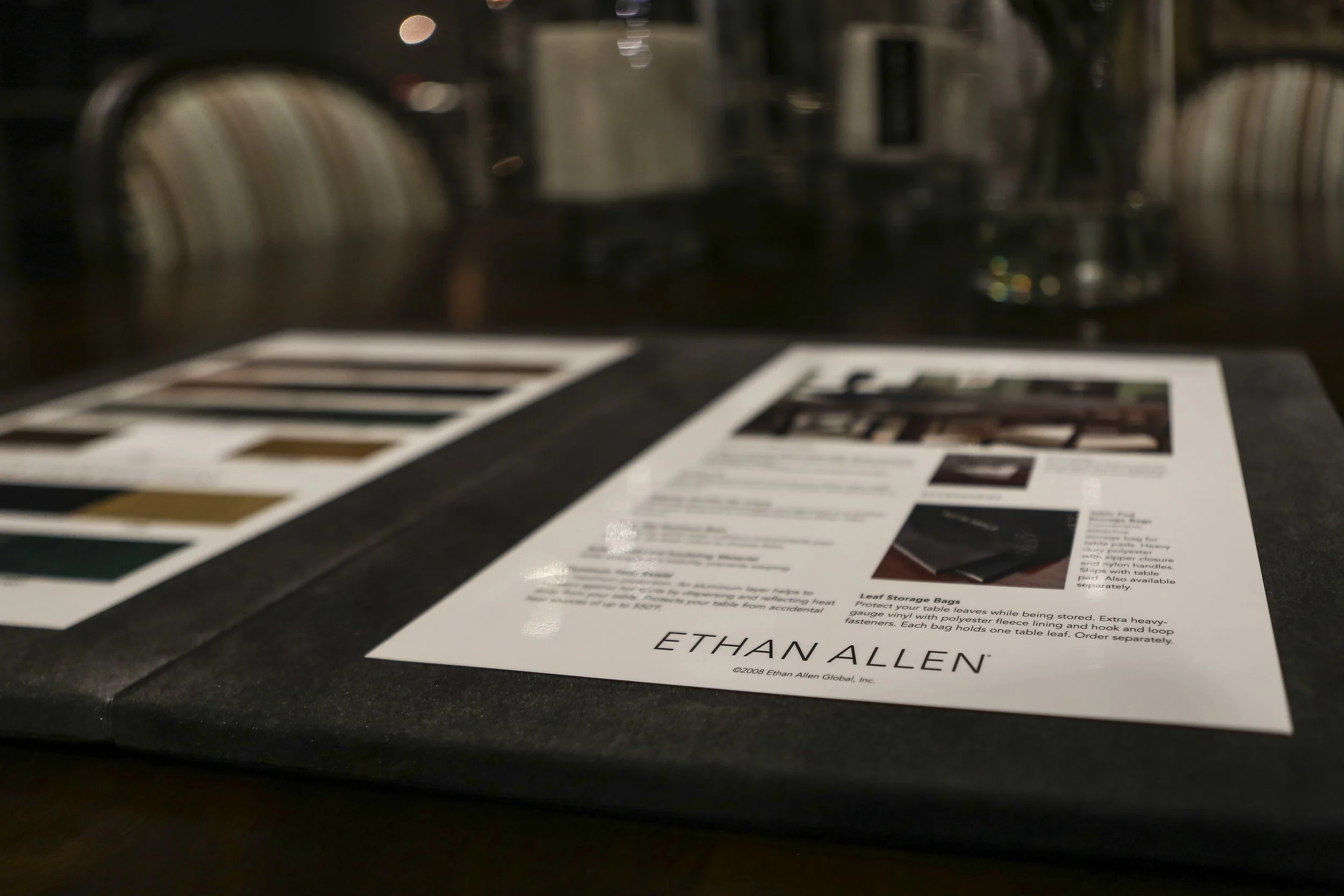 Close-up of a printed sheet on a dark surface with a blurred background of kitchen appliances and bookshelves.