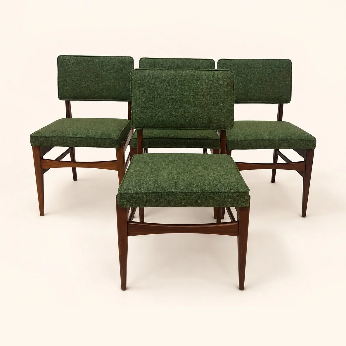 Set of wooden dining chairs reupholstered in green fabric.