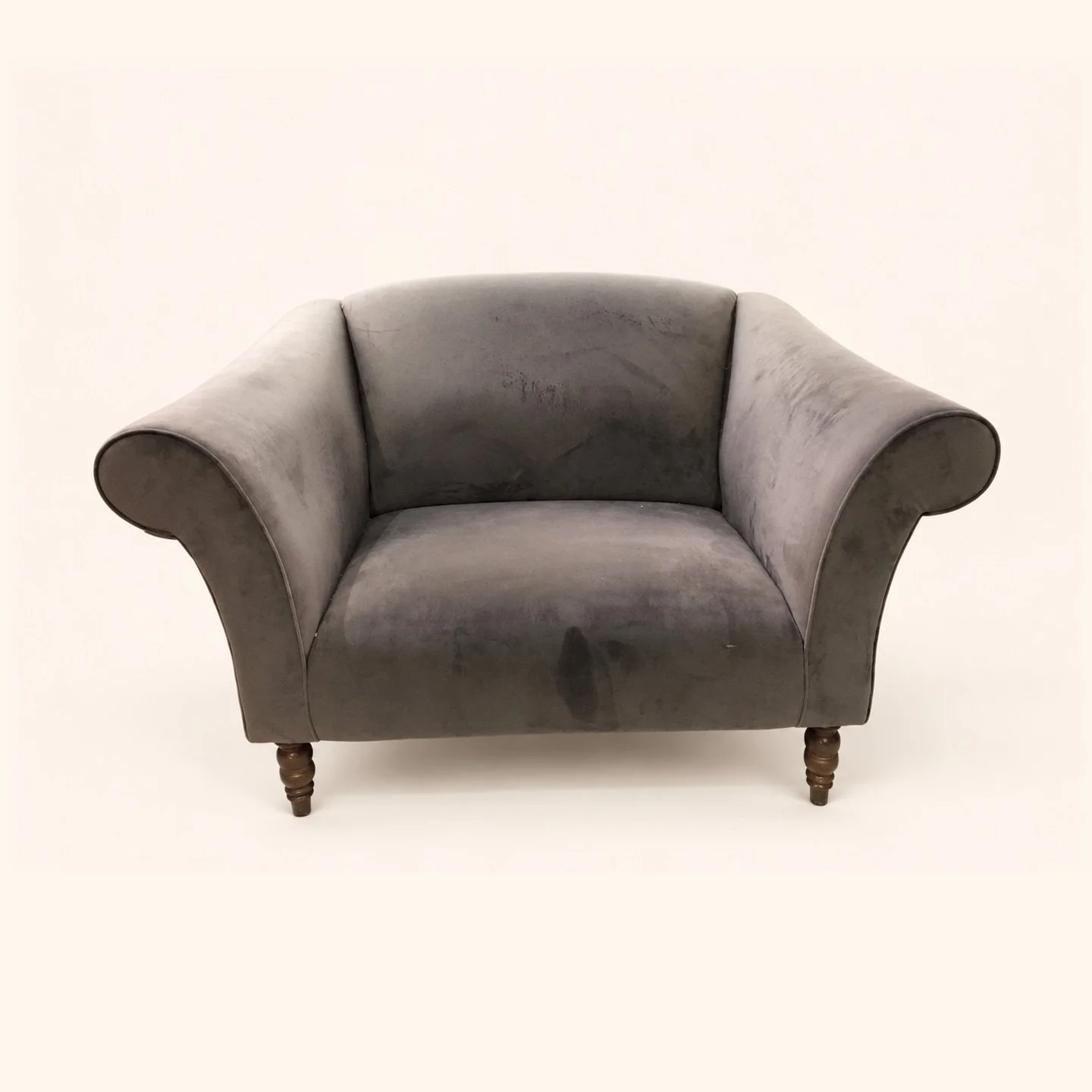 Curved tub chair with worn grey upholstery before reupholstery.