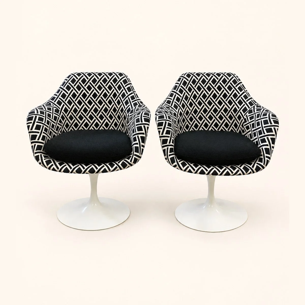 After reupholstery: two pedestal chairs in black and white geometric fabric, with black seat cushions and white bases.