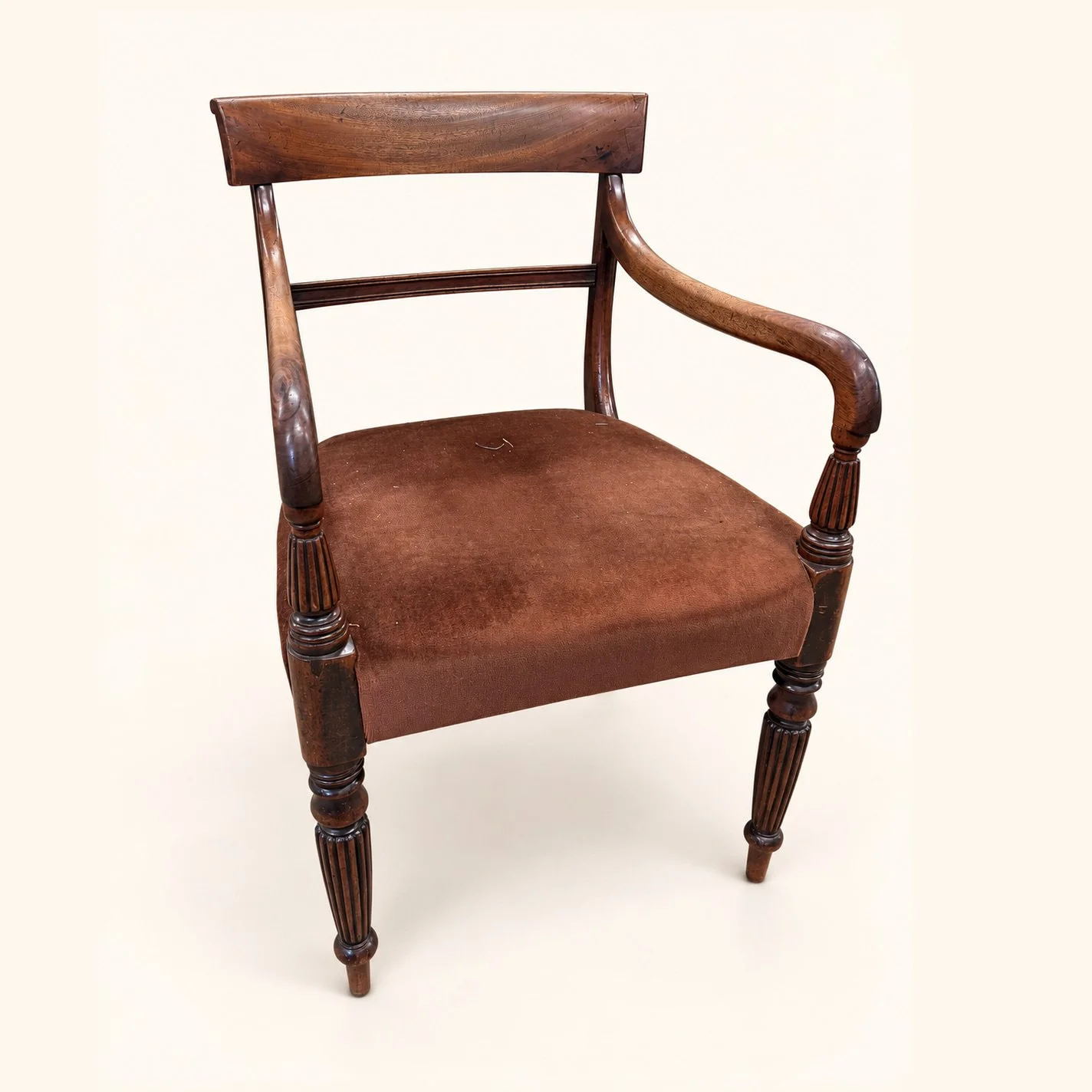Before reupholstery: a wooden dining armchair with a plain brown upholstered seat, curved arms and turned front legs.
