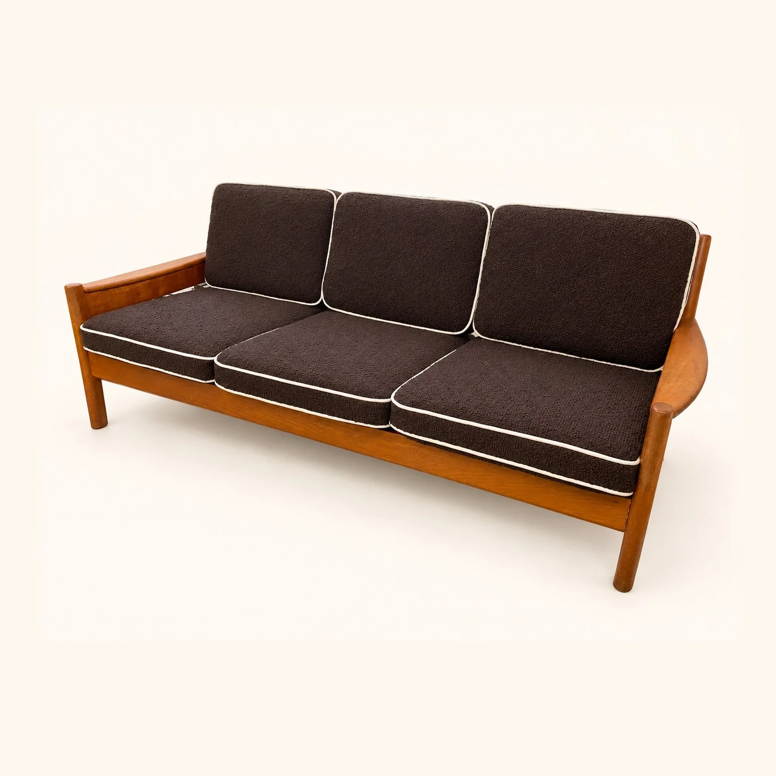 After reupholstery: a wooden three-seat sofa with dark brown seat and back cushions, pale piping and exposed wooden arms.