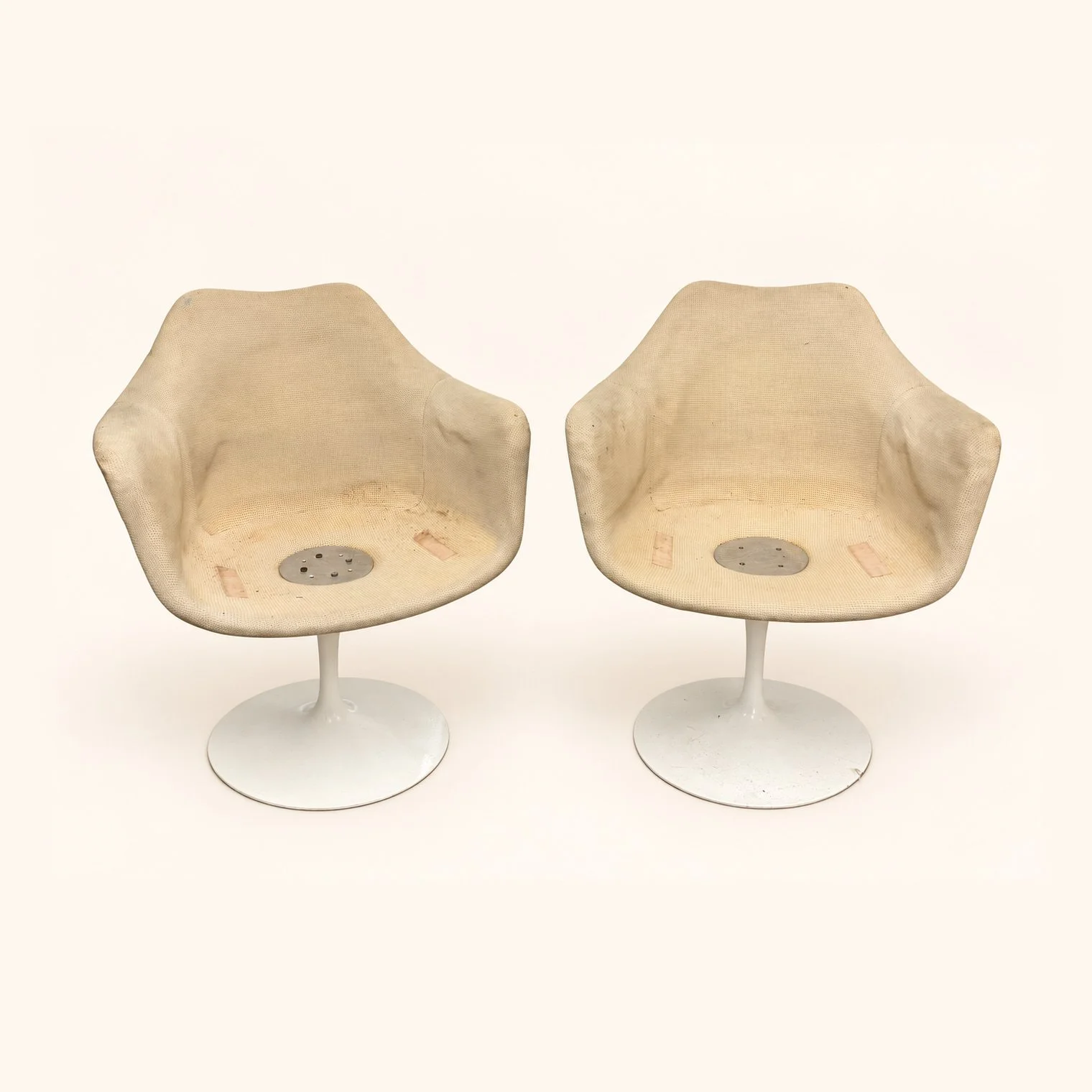 Before reupholstery: two moulded shell chairs with exposed seat interiors and white pedestal bases.