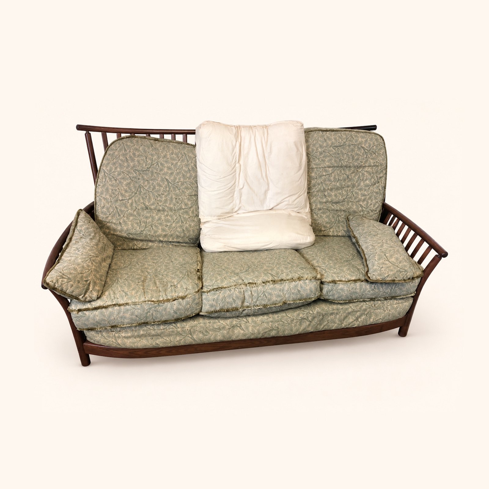 Ercol Renaissance Sofa with worn patterned cushions before reupholstery.