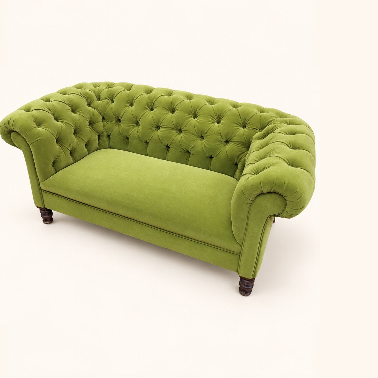 Before reupholstery: green Chesterfield sofa with a deep-buttoned back, rolled arms and wooden feet.