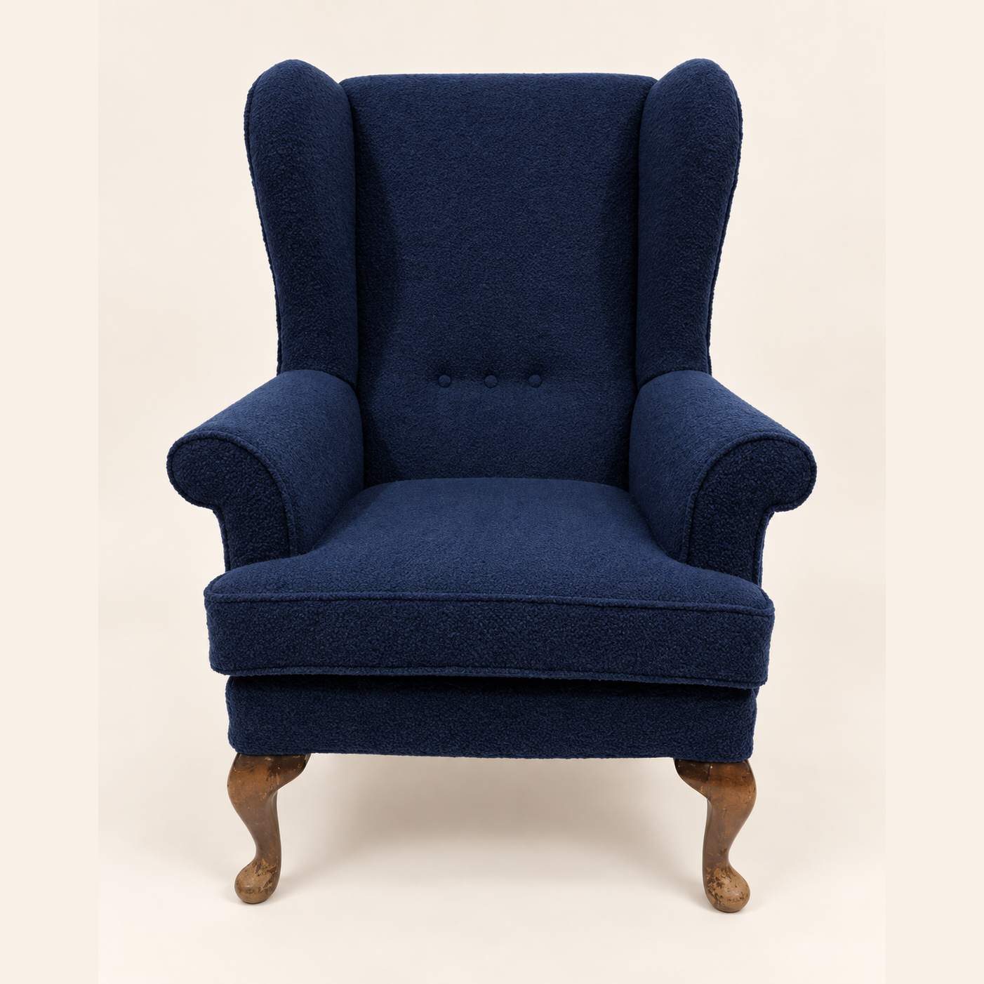 Parker Knoll Armchair after reupholstery, in navy blue fabric, with rolled arms, button details and wooden legs.