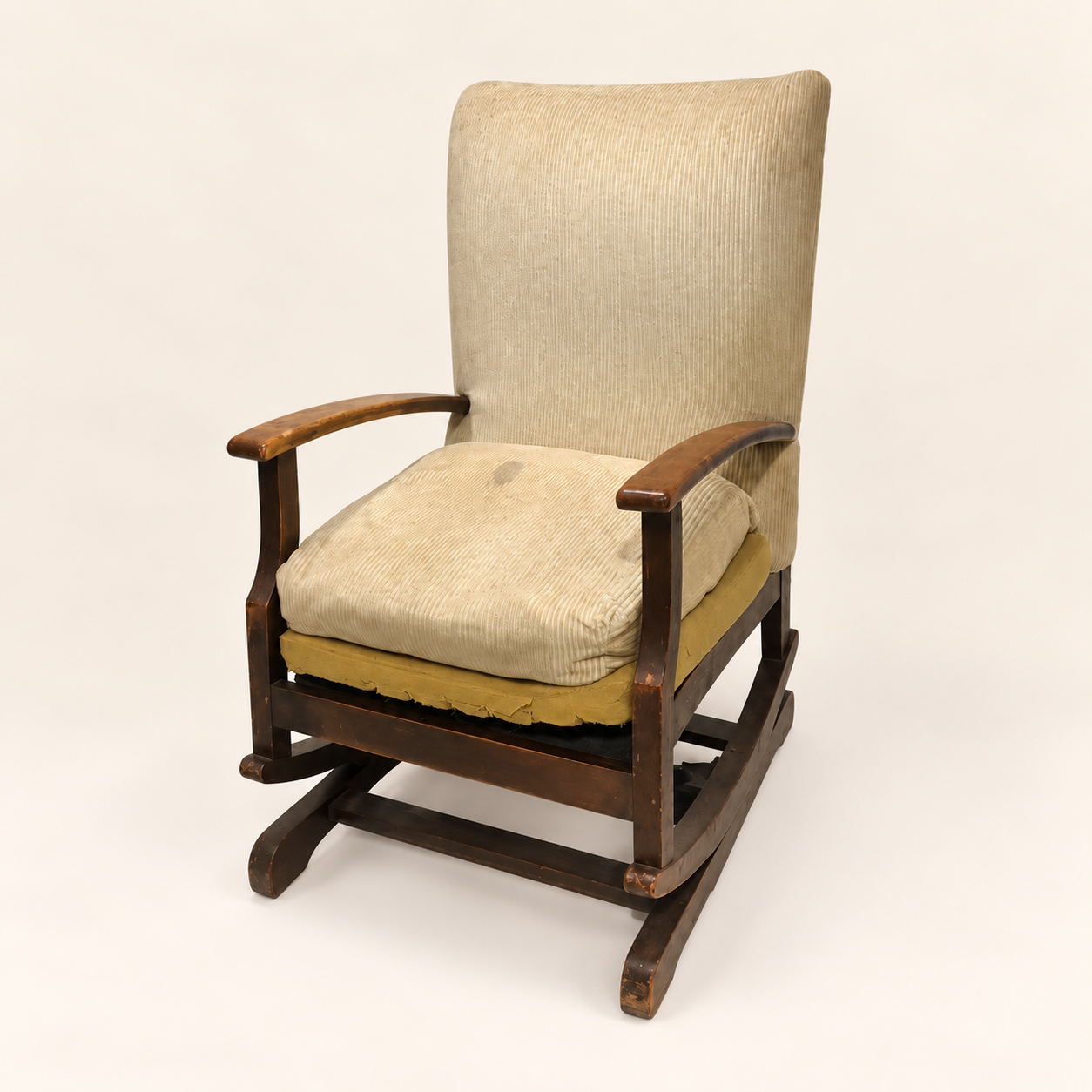 Before reupholstery: wooden rocking chair with worn cream seat and back upholstery.