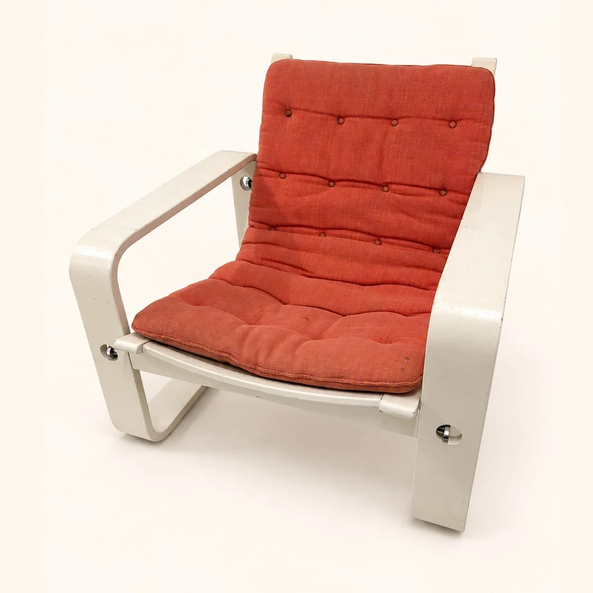 Before reupholstery: a white-frame lounge chair with a red padded seat and back, slender arms and curved runners.