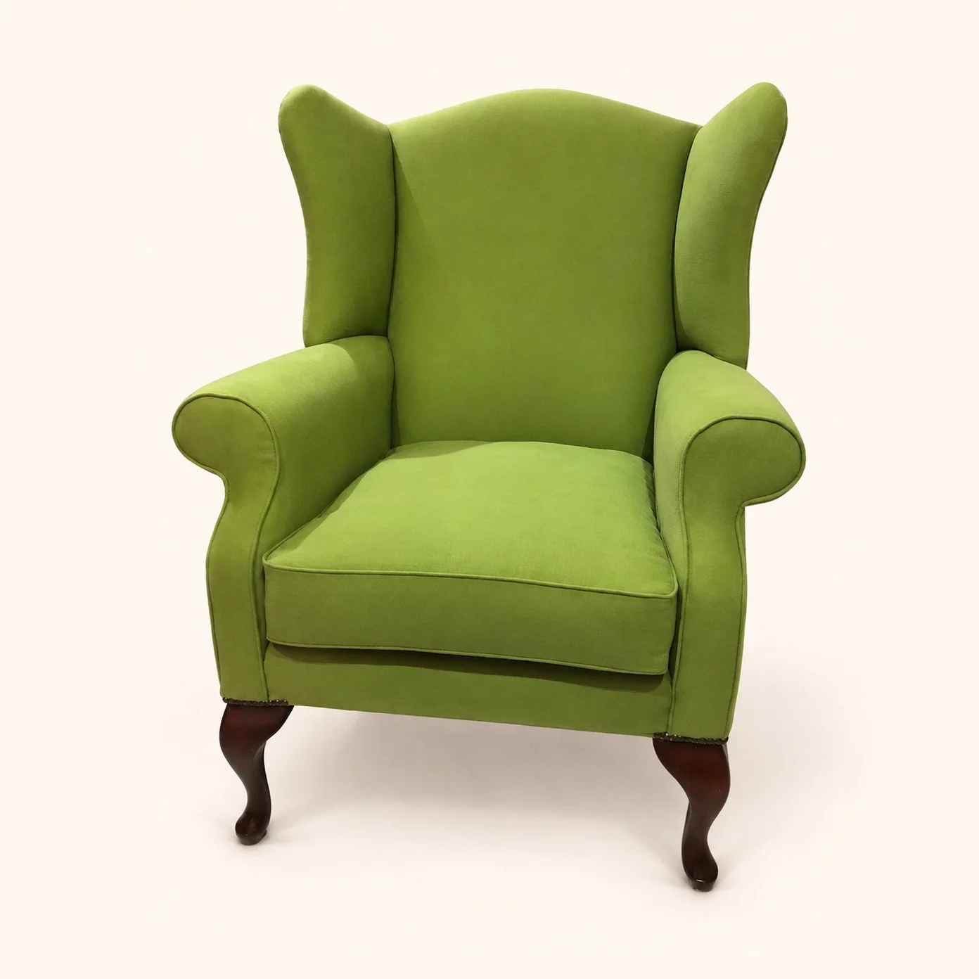 Wingback armchair reupholstered in bright green fabric.