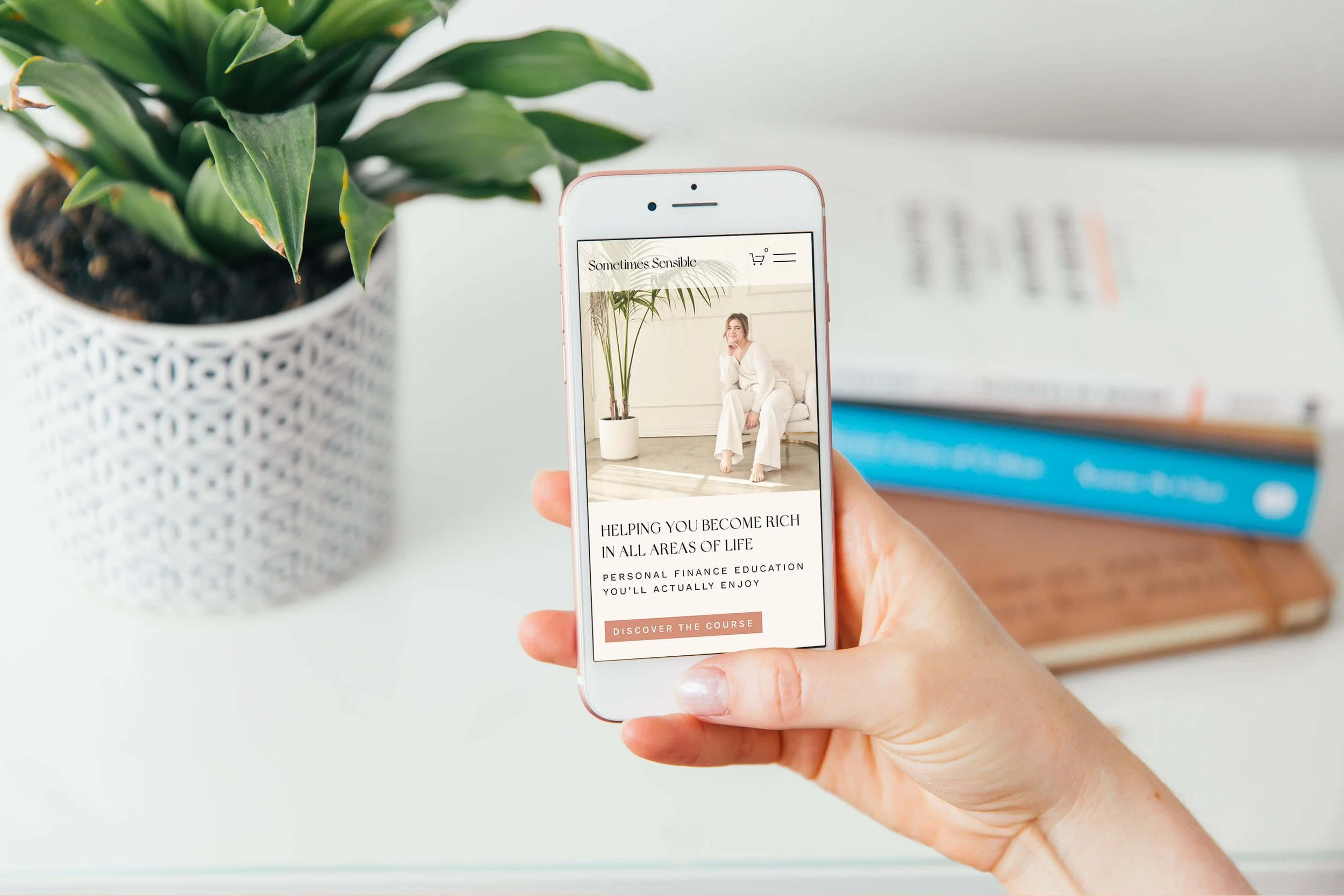 Hand holding mobile with Squarespace  website homepage open for a coach