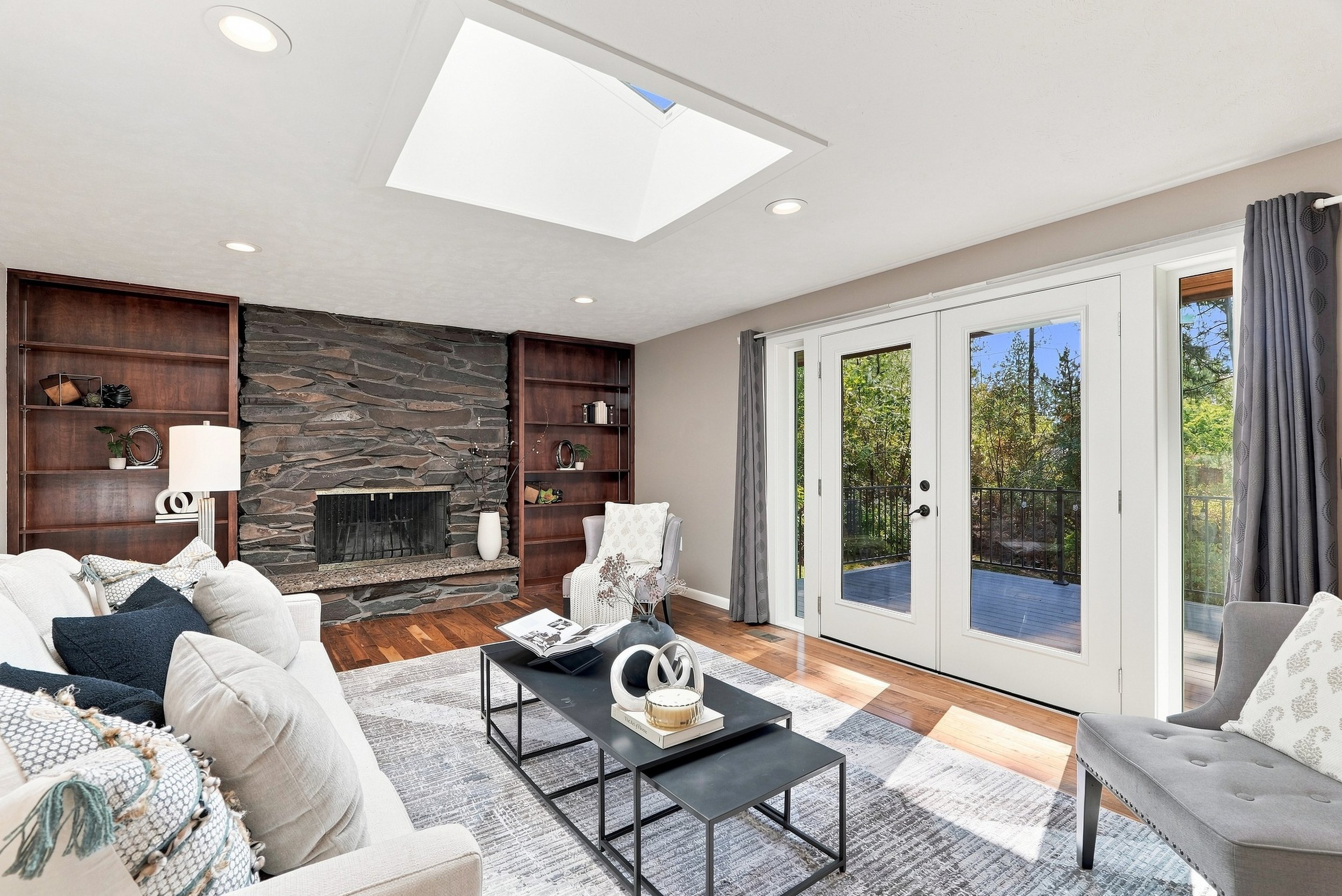 A living room with wood built-ins, a brick fireplace and a softly styled cream sofa. Staging by Home Staging Works.