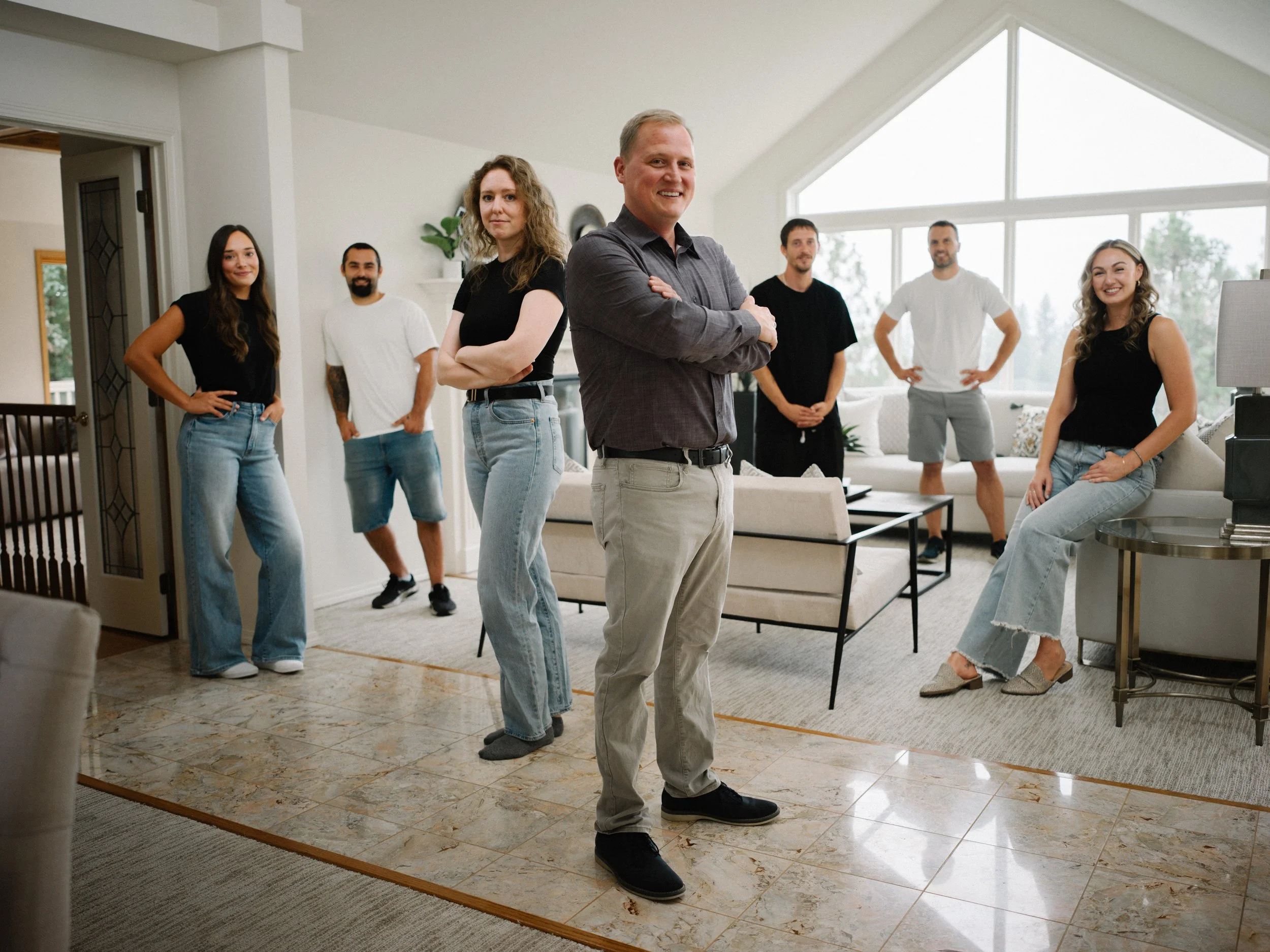 The Home Staging Works team standing together in a professionally staged living room in Spokane, illustrating our collaborative approach to home staging in the Inland Northwest.