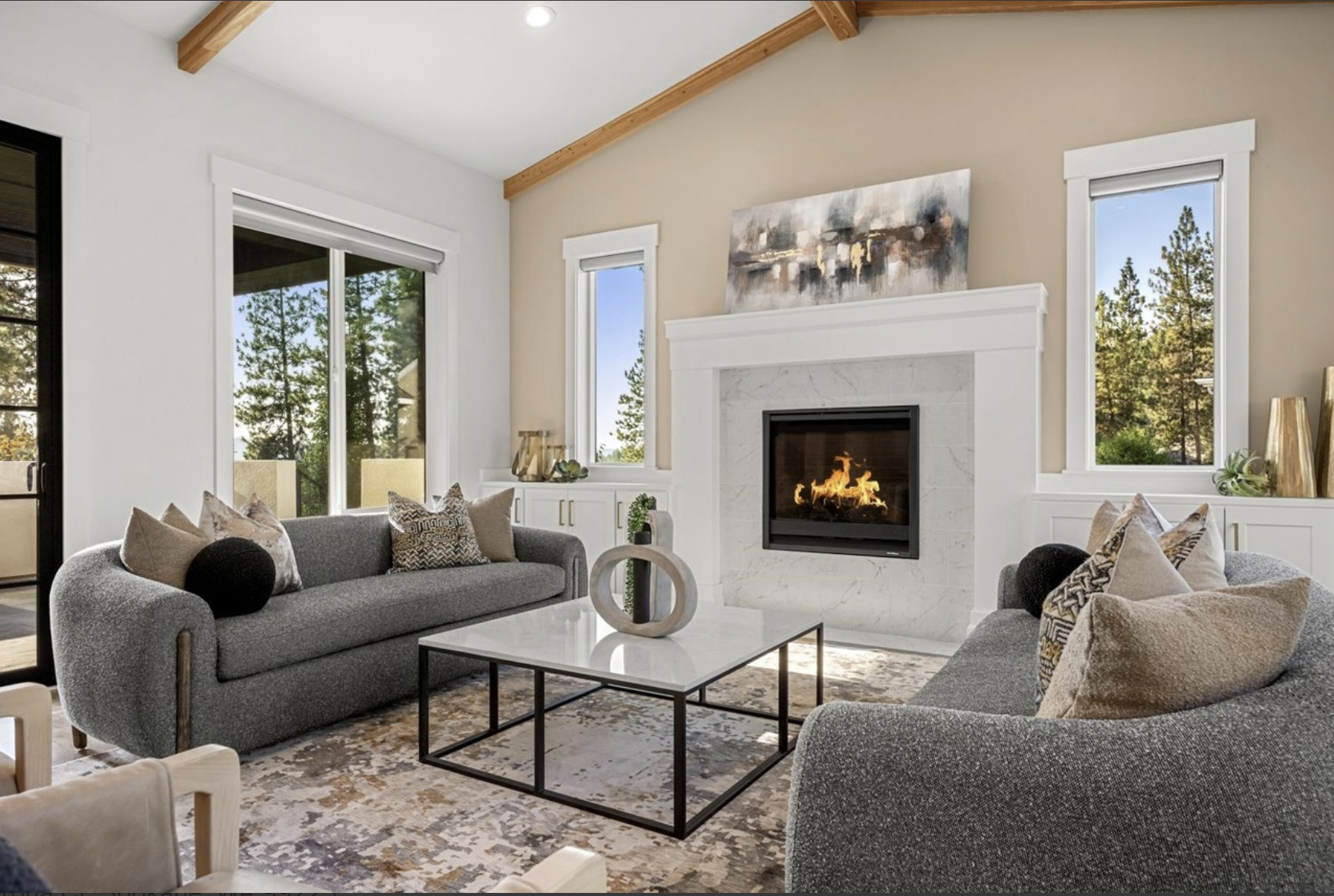 Professionally staged living room featuring a stone fireplace, neutral sofas and large windows — showcasing the inviting spaces Home Staging Works creates in Spokane and Coeur d’Alene.