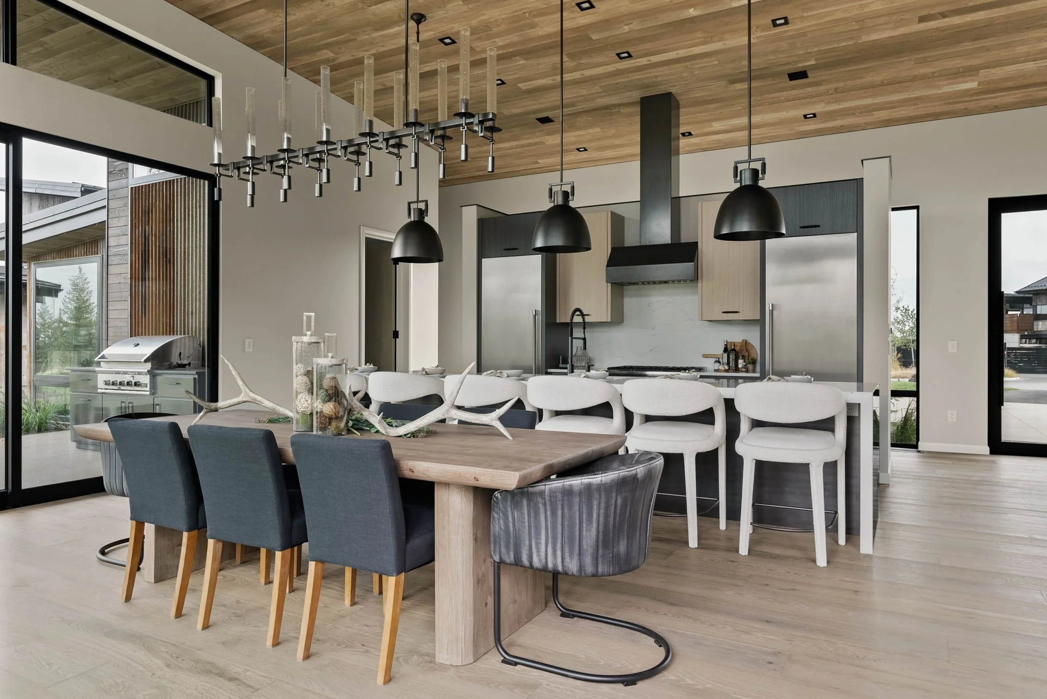 Spacious dining area with a long wooden table, modern pendant lights and seating for ten, styled for entertaining