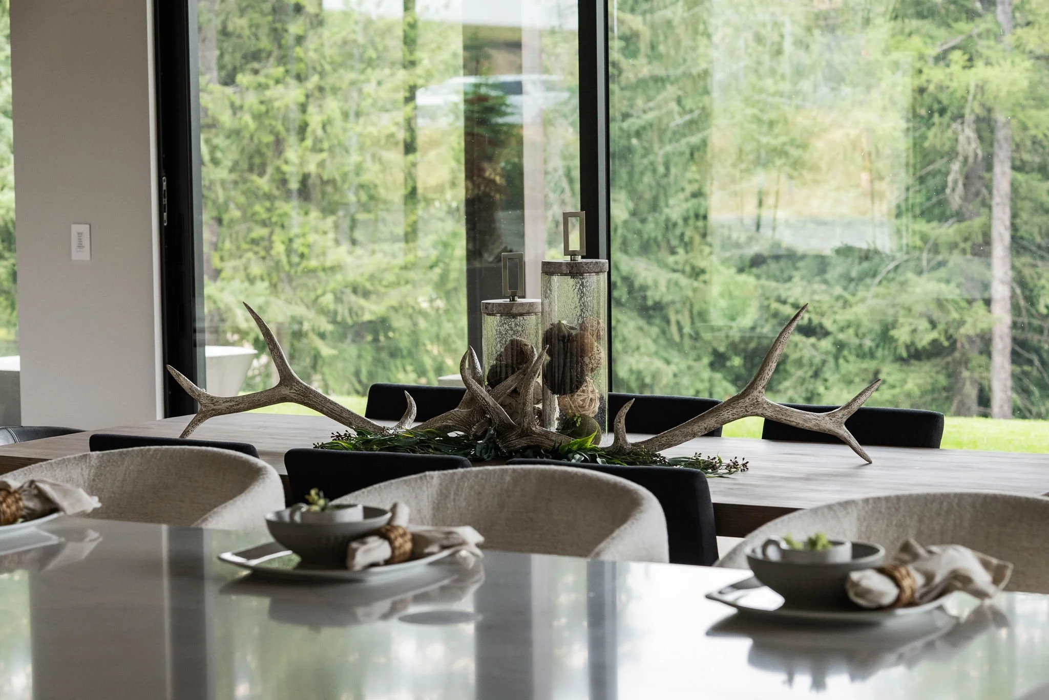 Detail shot of a dining table with contemporary centerpieces and tableware, showcasing the curated accents used in staging