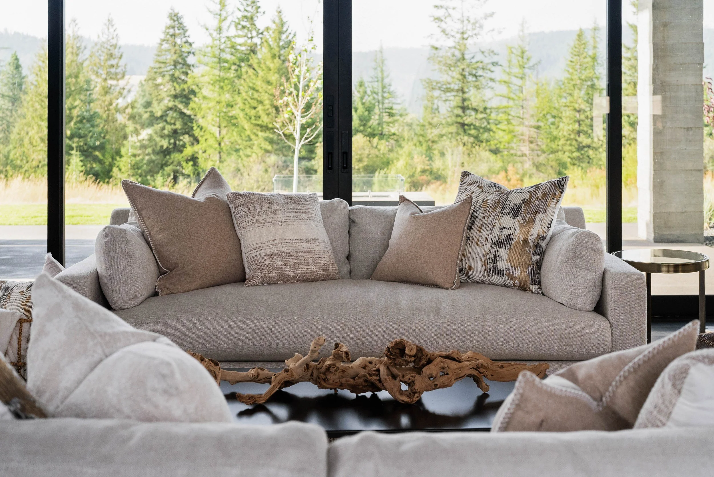 Generously scaled cream seating, layered cushions and a sculptural wood accent in HSW’s CDA National Reserve staging.