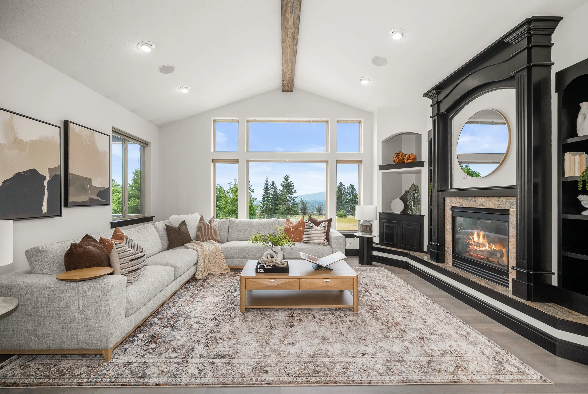 HSW-staged living room with a cream sectional, layered textiles and a dark architectural fireplace.