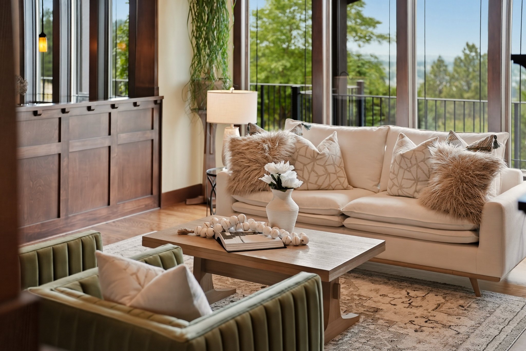 Warm wood architecture, a green accent chair and an inviting cream sofa. Staging by Home Staging Works.