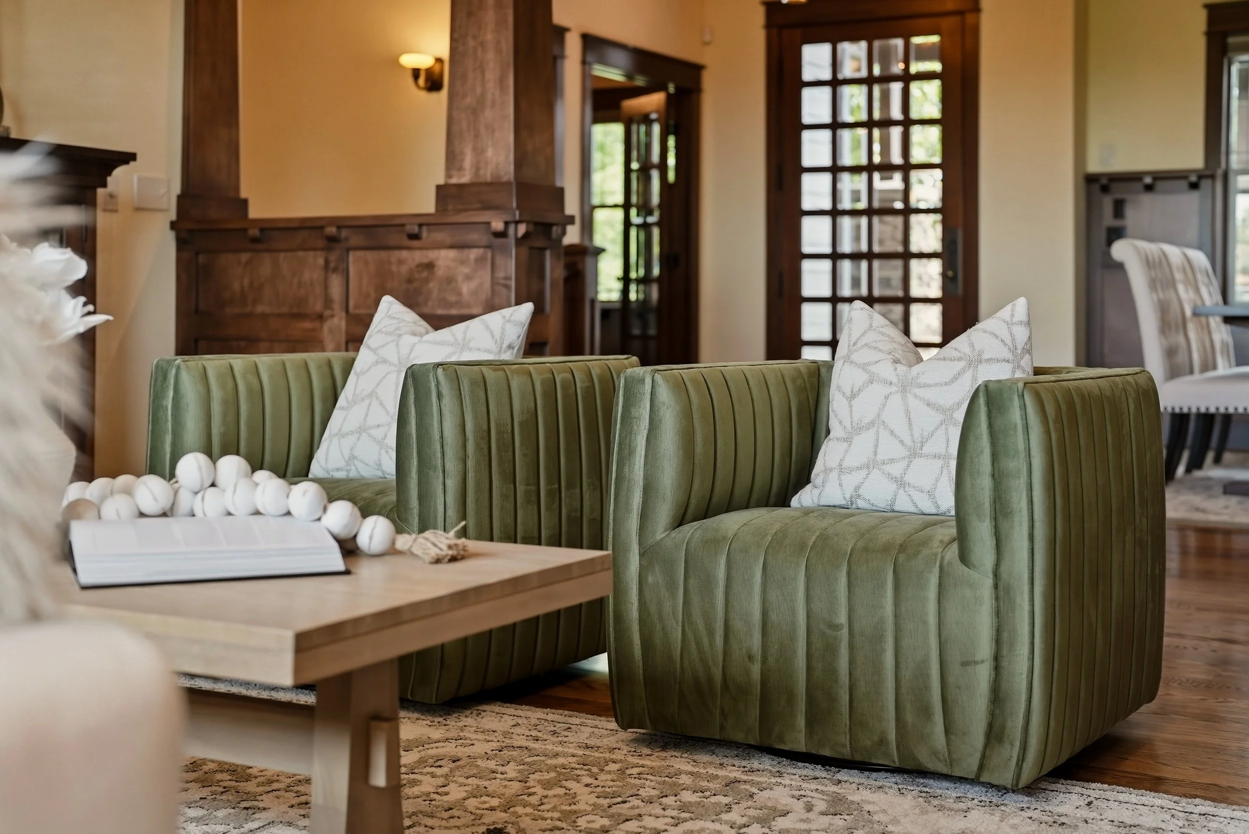 Warm wood details, olive-green seating and natural textures in a living room styled by HSW.
