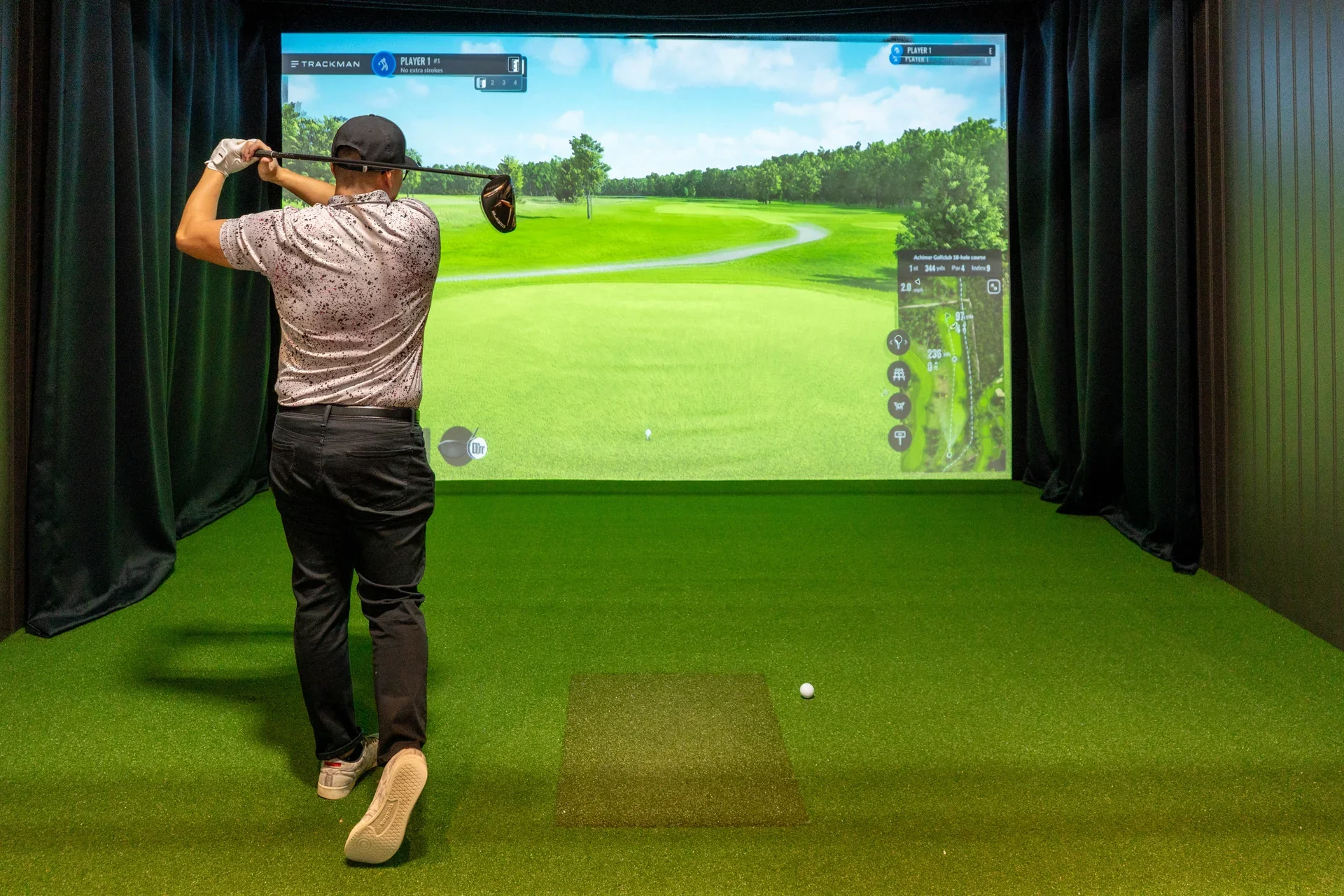 Golf in a Trackman simulator bay at Maple Indoor Golf