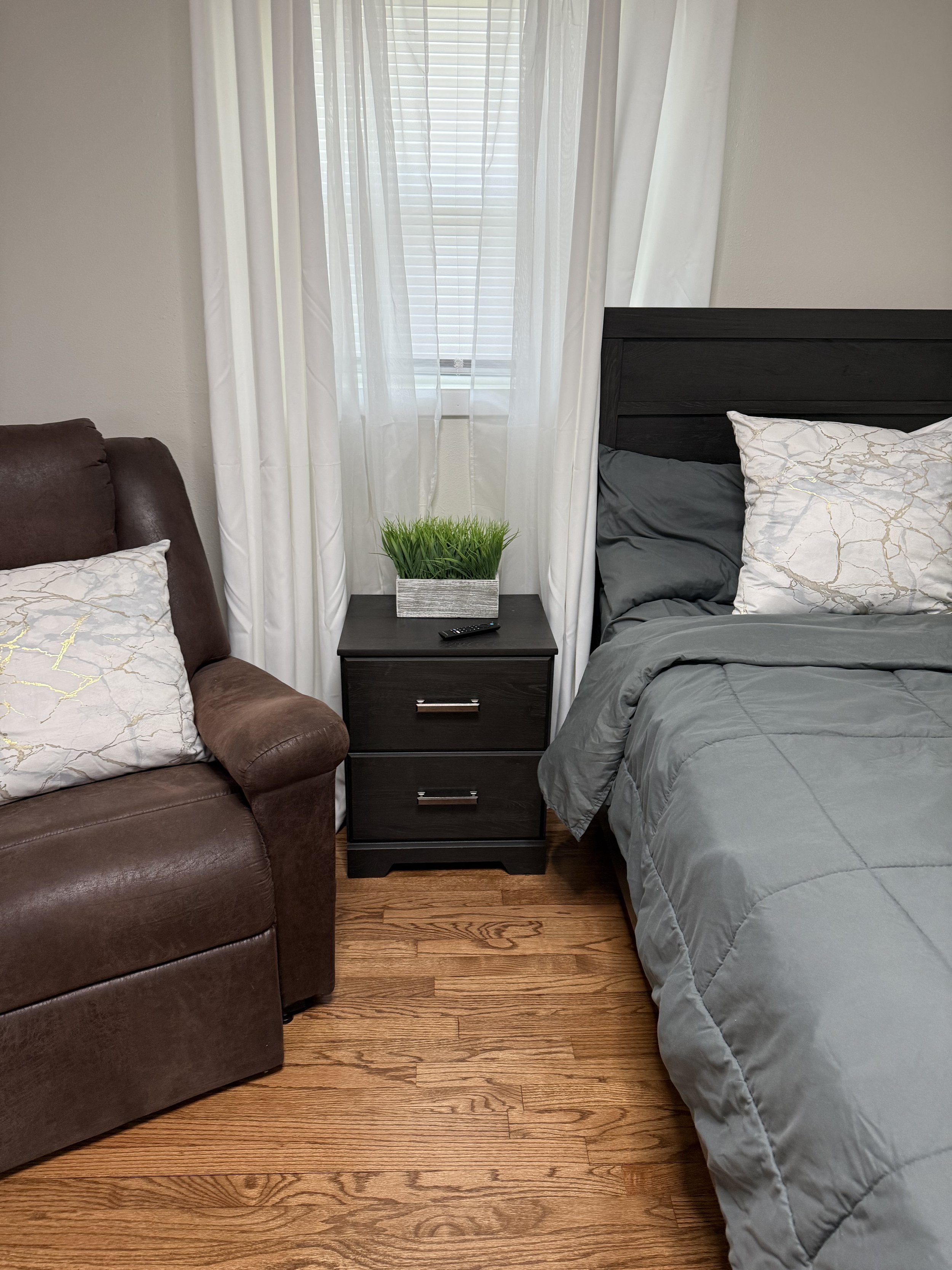 Bedroom at Vital Care Comfort Home with bed, chair and side table