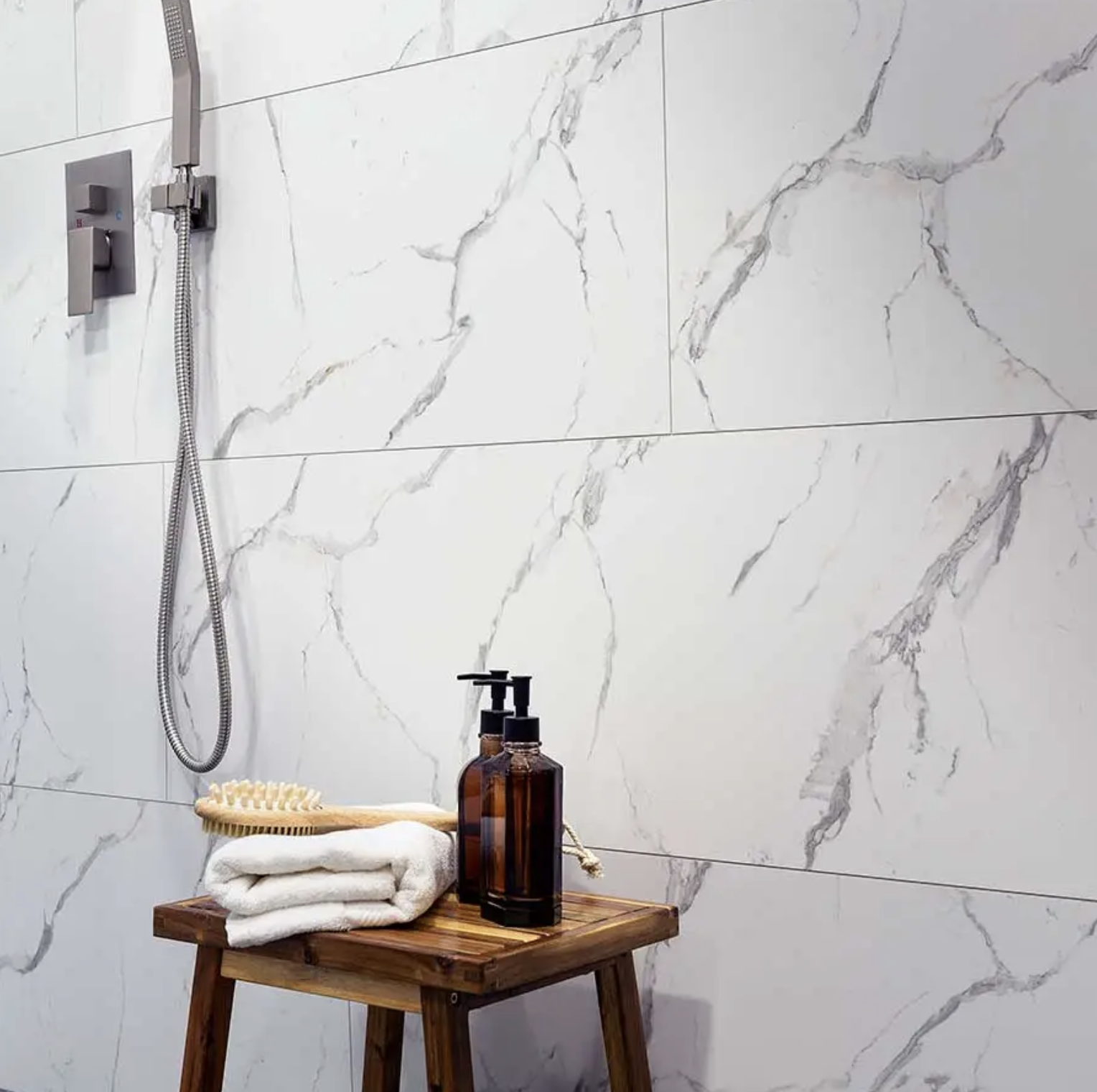 White marble look, teak seat with towels:
White marble-look waterproof shower wall panels with no grout lines and a handheld shower head