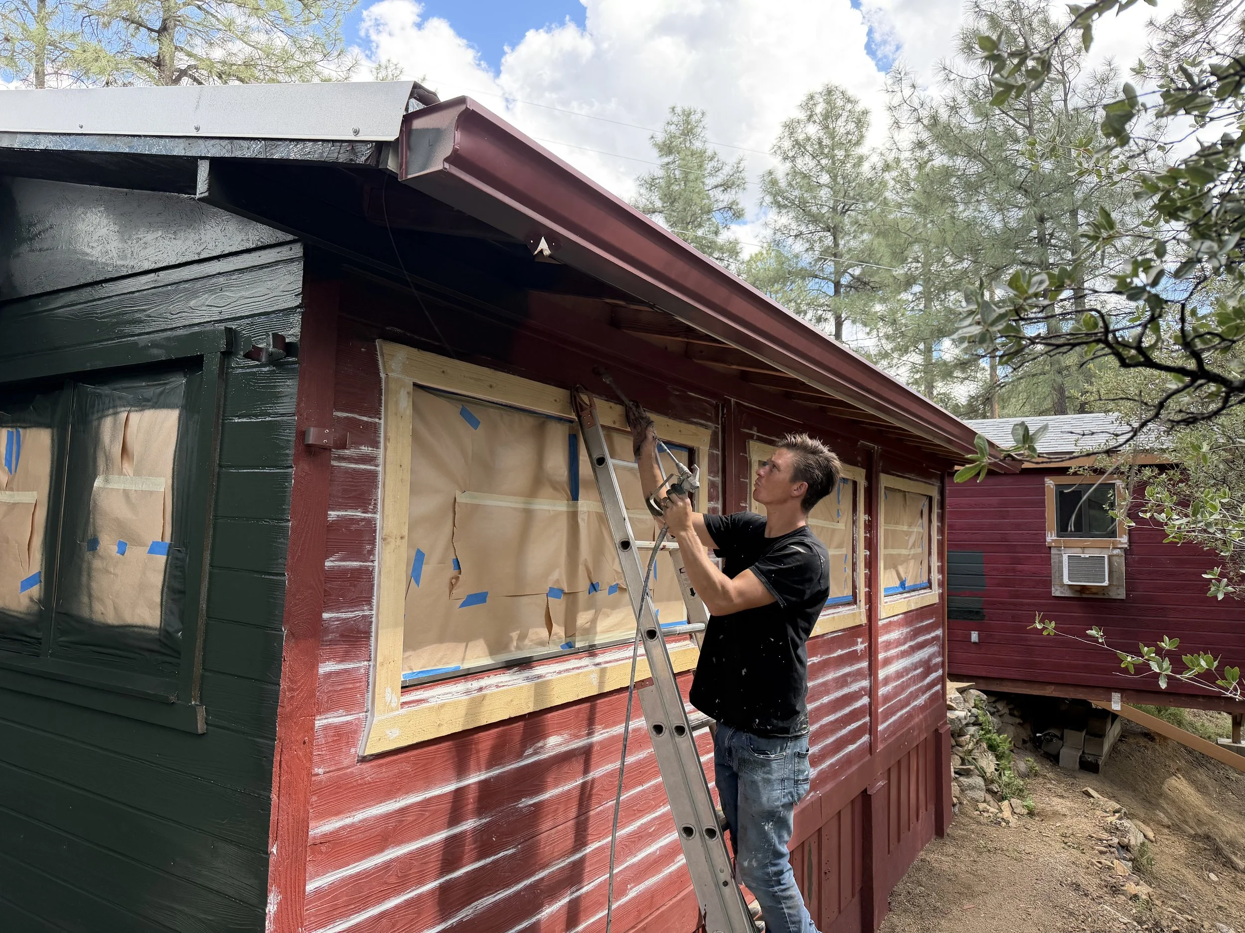 Painting the exterior of a cabin during a Prescott, Arizona home improvement project.