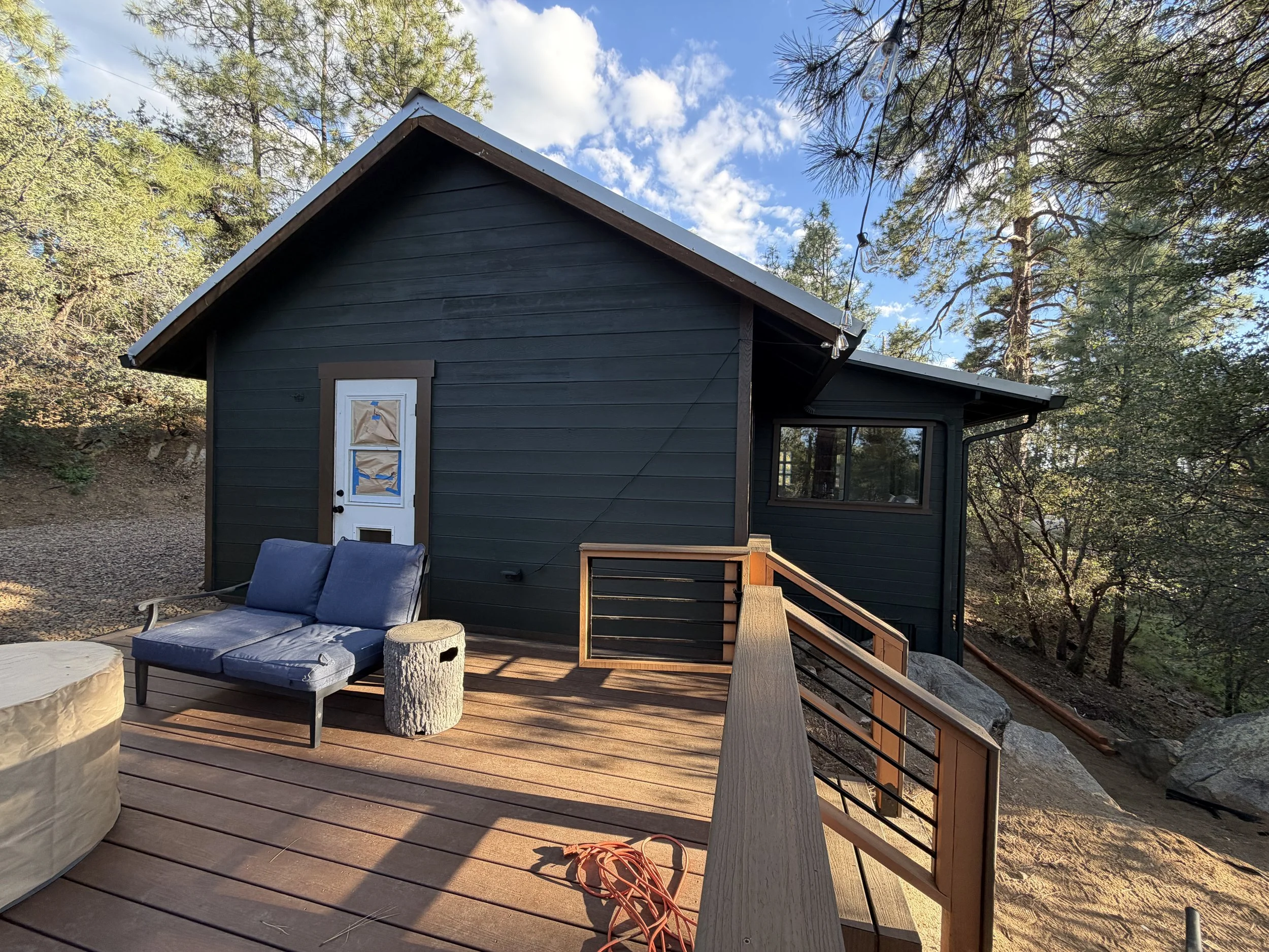 Finished cabin exterior with new deck and green paint during a Prescott, Arizona renovation project.
