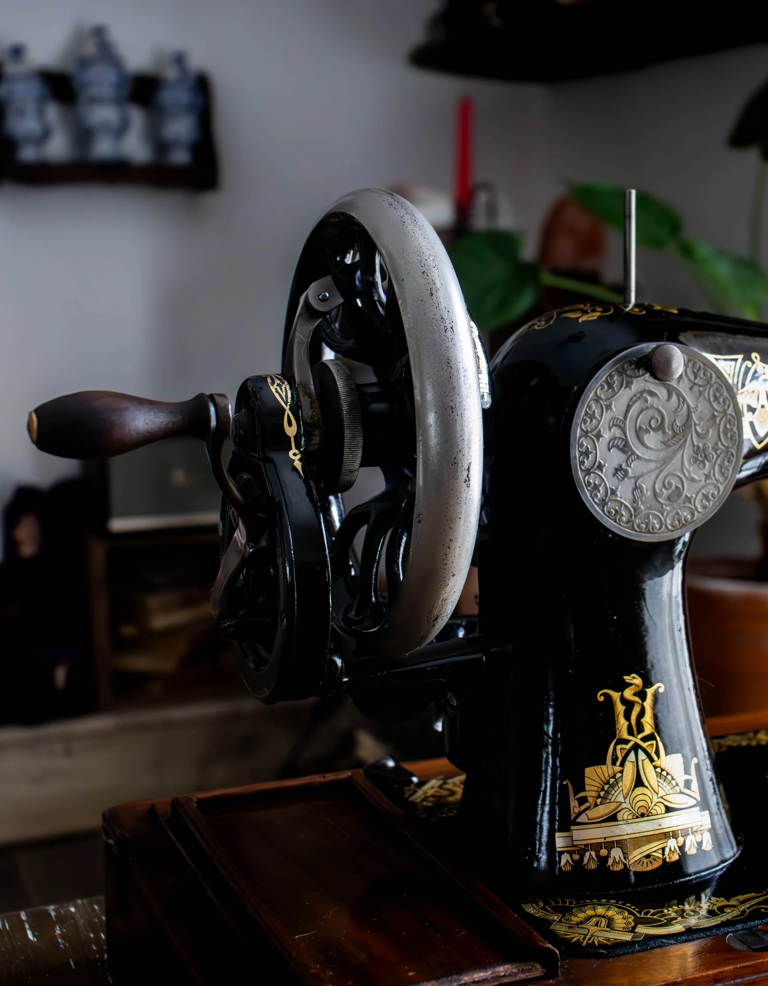 Une machine à café avec décorations dorées, un manche en bois, et des éléments en métal avec un motif élégant.