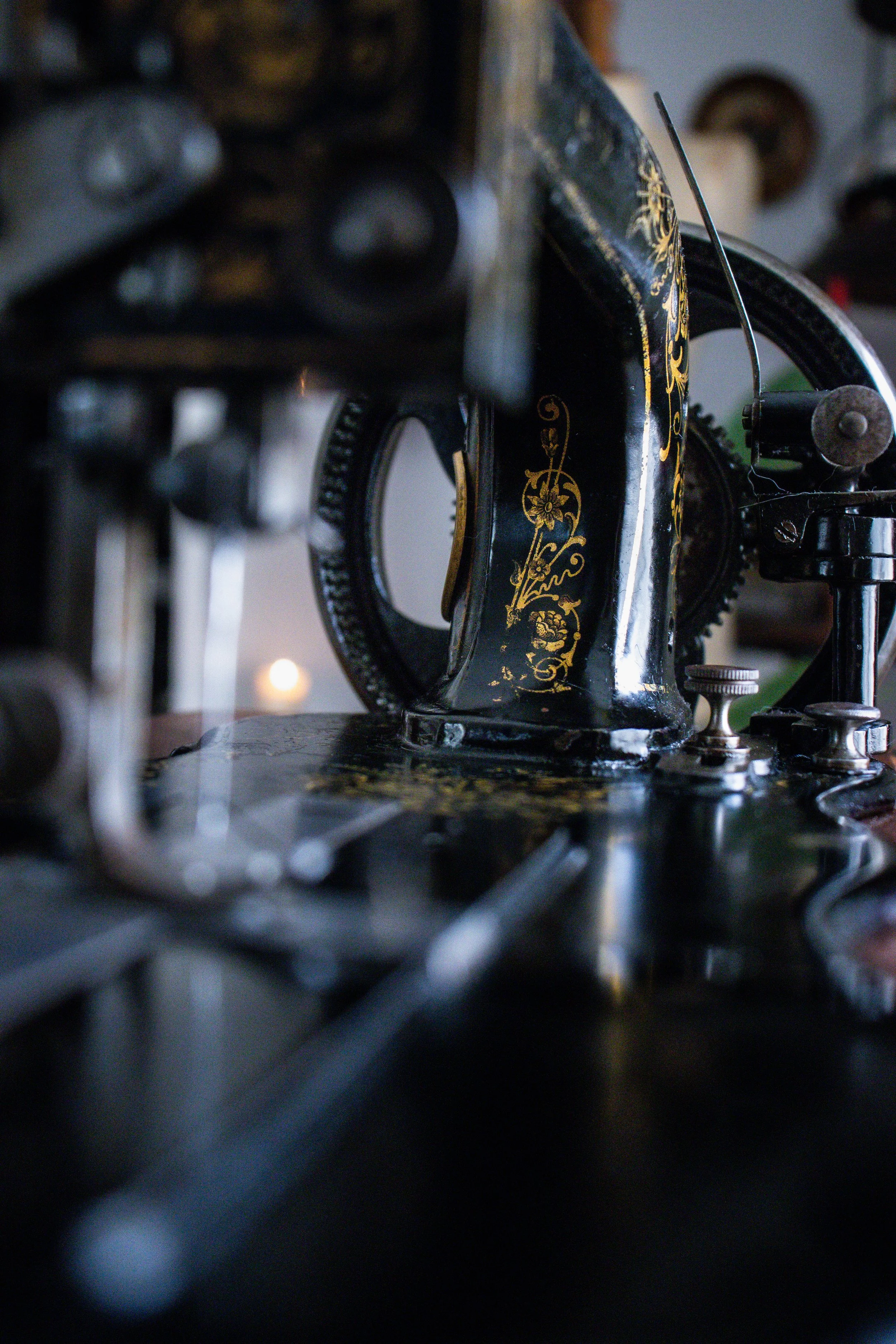 Une machine à coudre ancienne avec décorations dorées sur le corps noir.