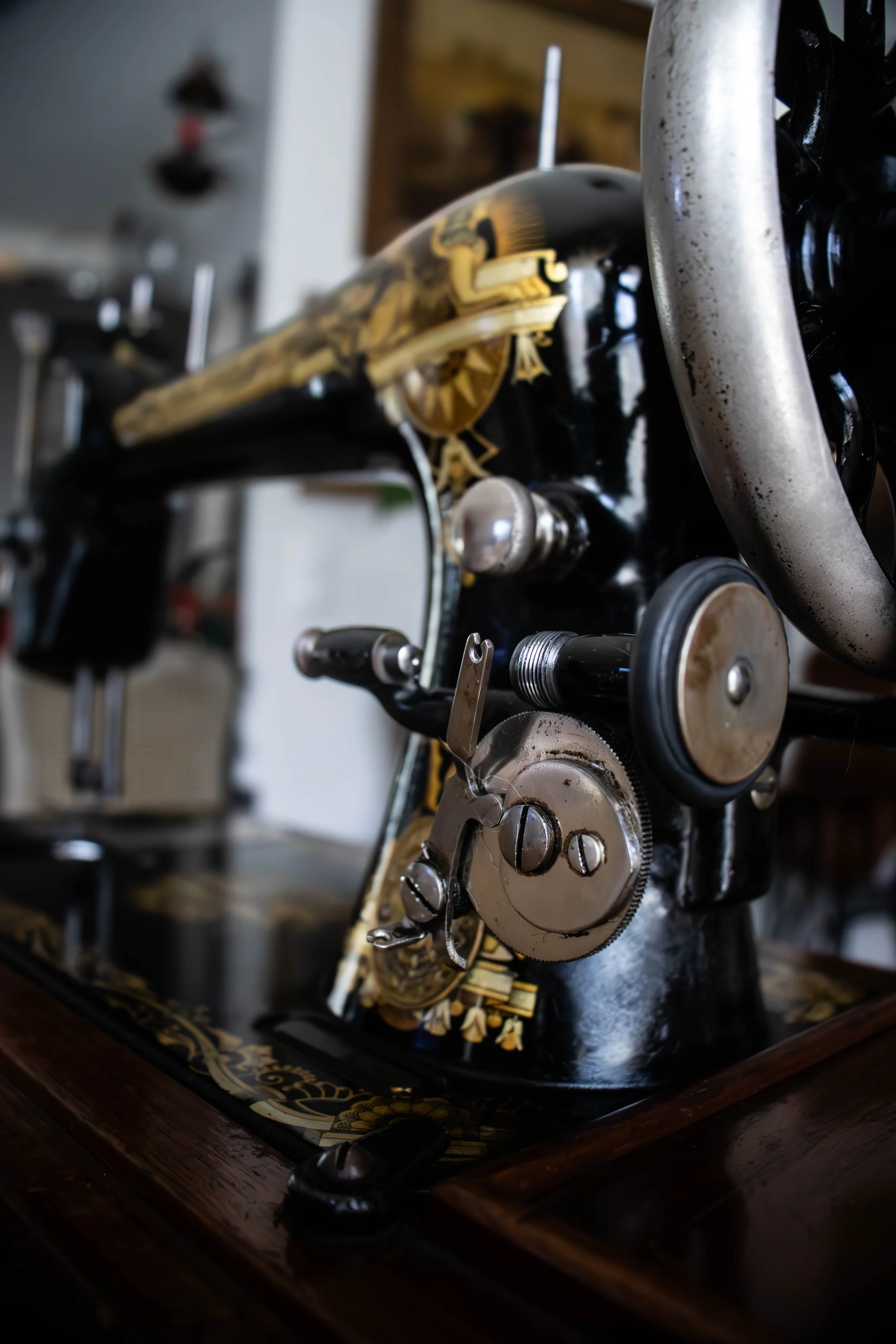 Mécanisme de machine à coudre antique avec engrenages en métal, sur une surface en bois.