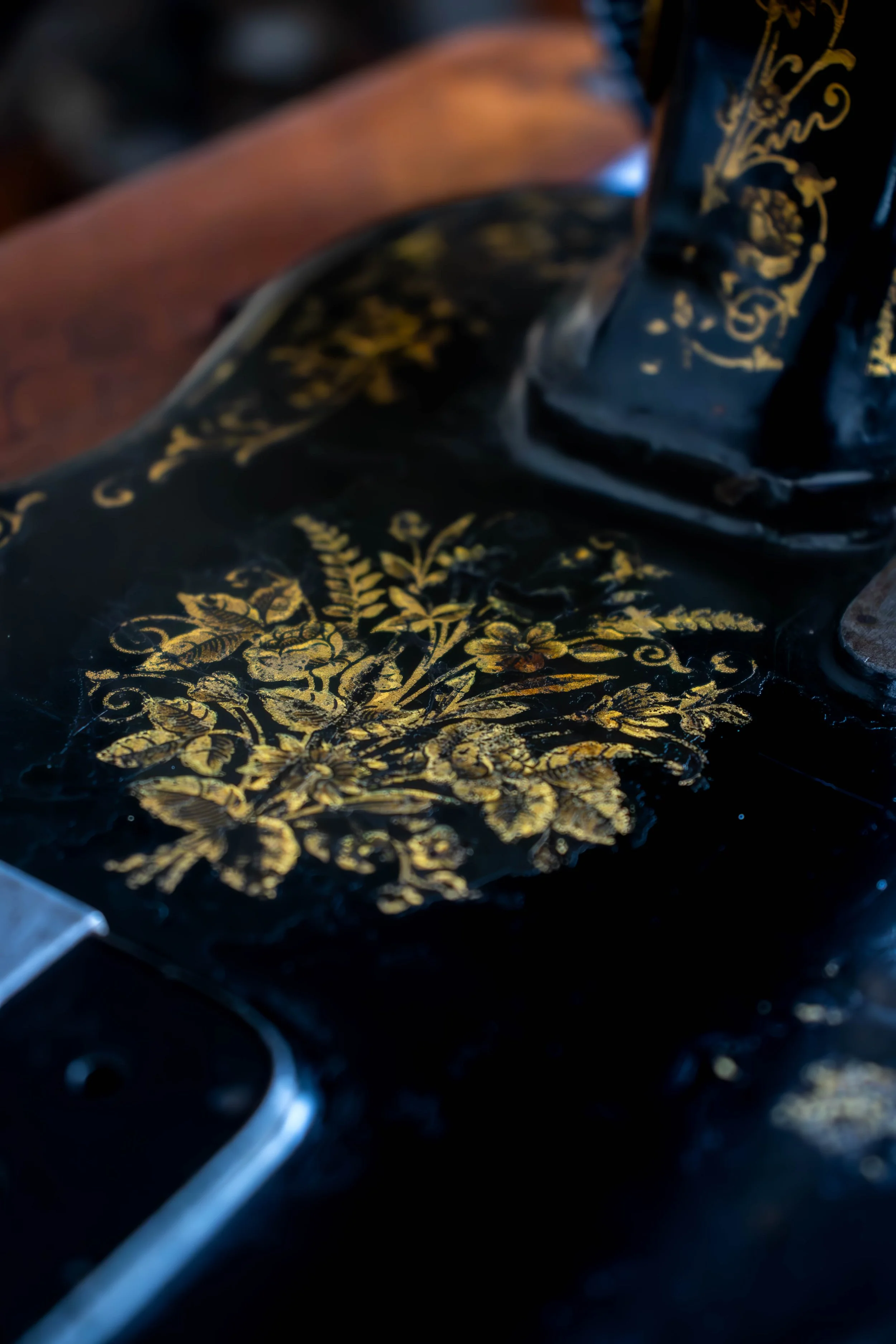 Un art carpenterie avec des motifs floraux en or sur un fond noir, en train d'être fabriqué ou réparé.